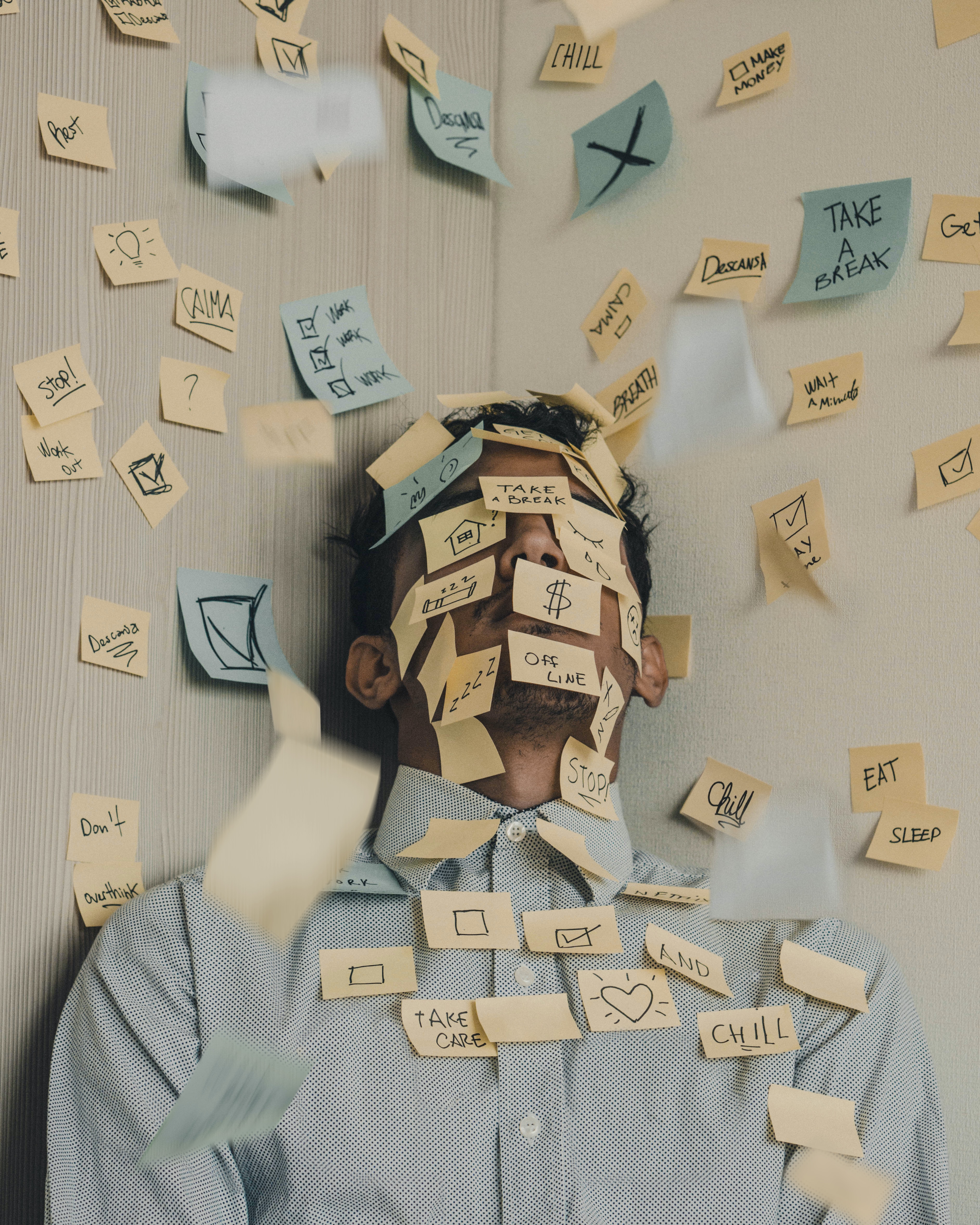 Man against the wall with sticky notes on his face and the wall