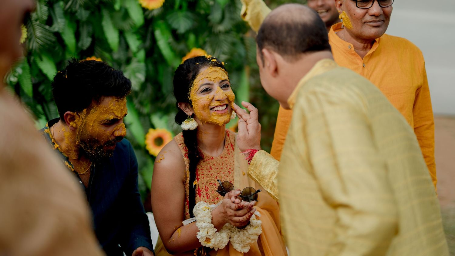 haldi ceremony bride smiling turmeric ritual family interaction wedding photography