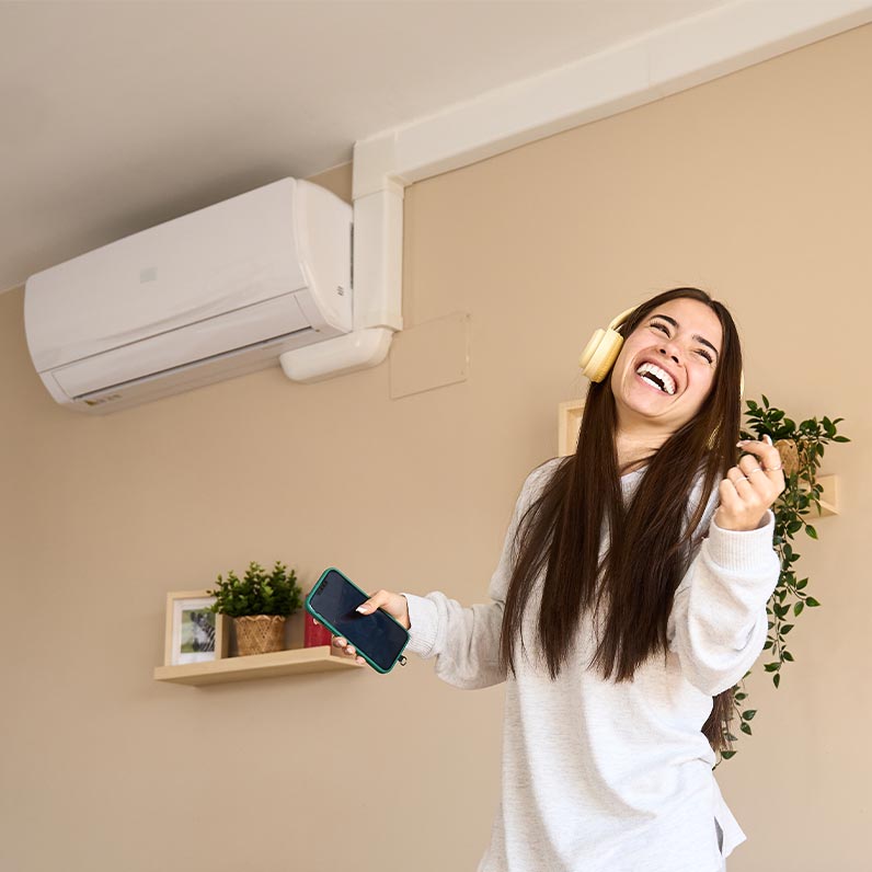Настінний кондиціонер у кімнаті з сучасним дизайном і задоволеною користувачкою