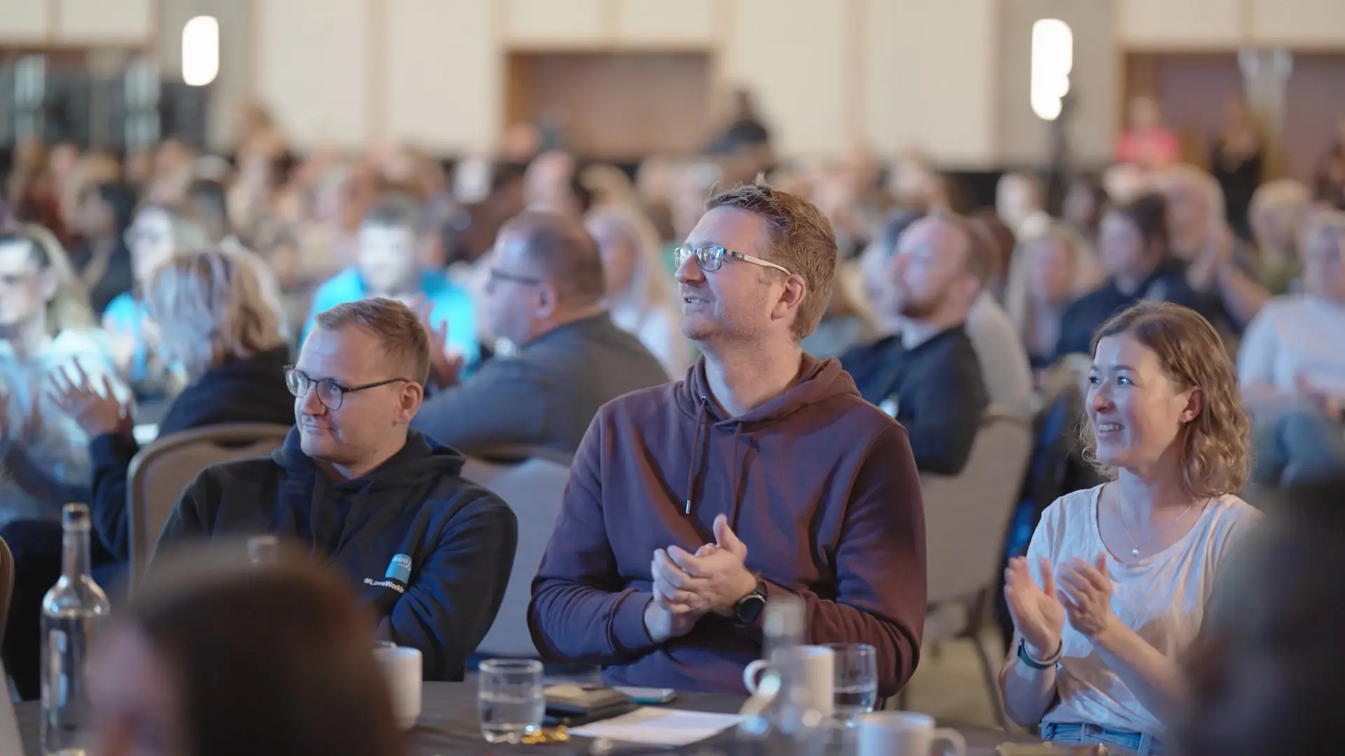Audience members applauding during a keynote session at the Bupa Care event.