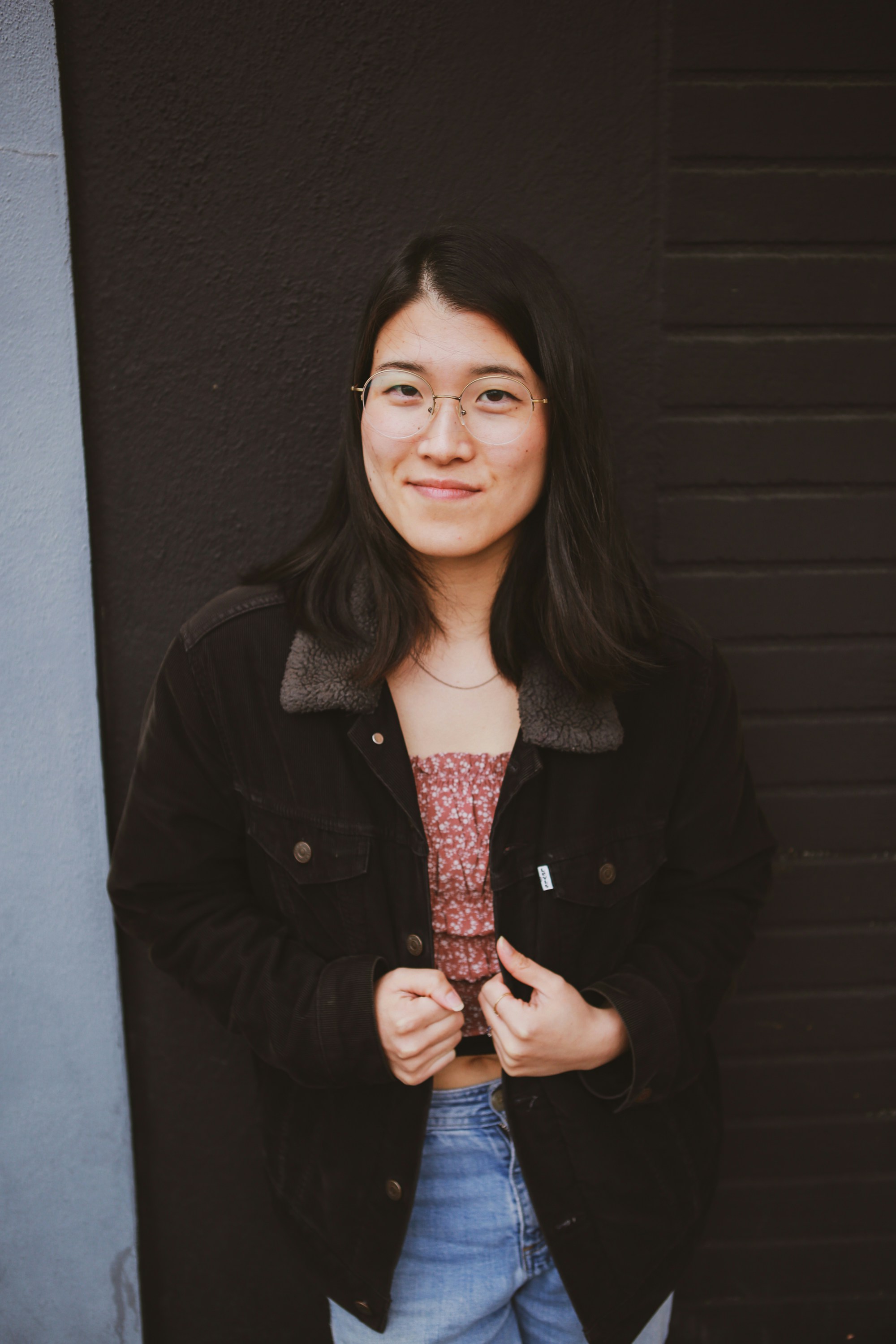 a woman standing in front of a black wall