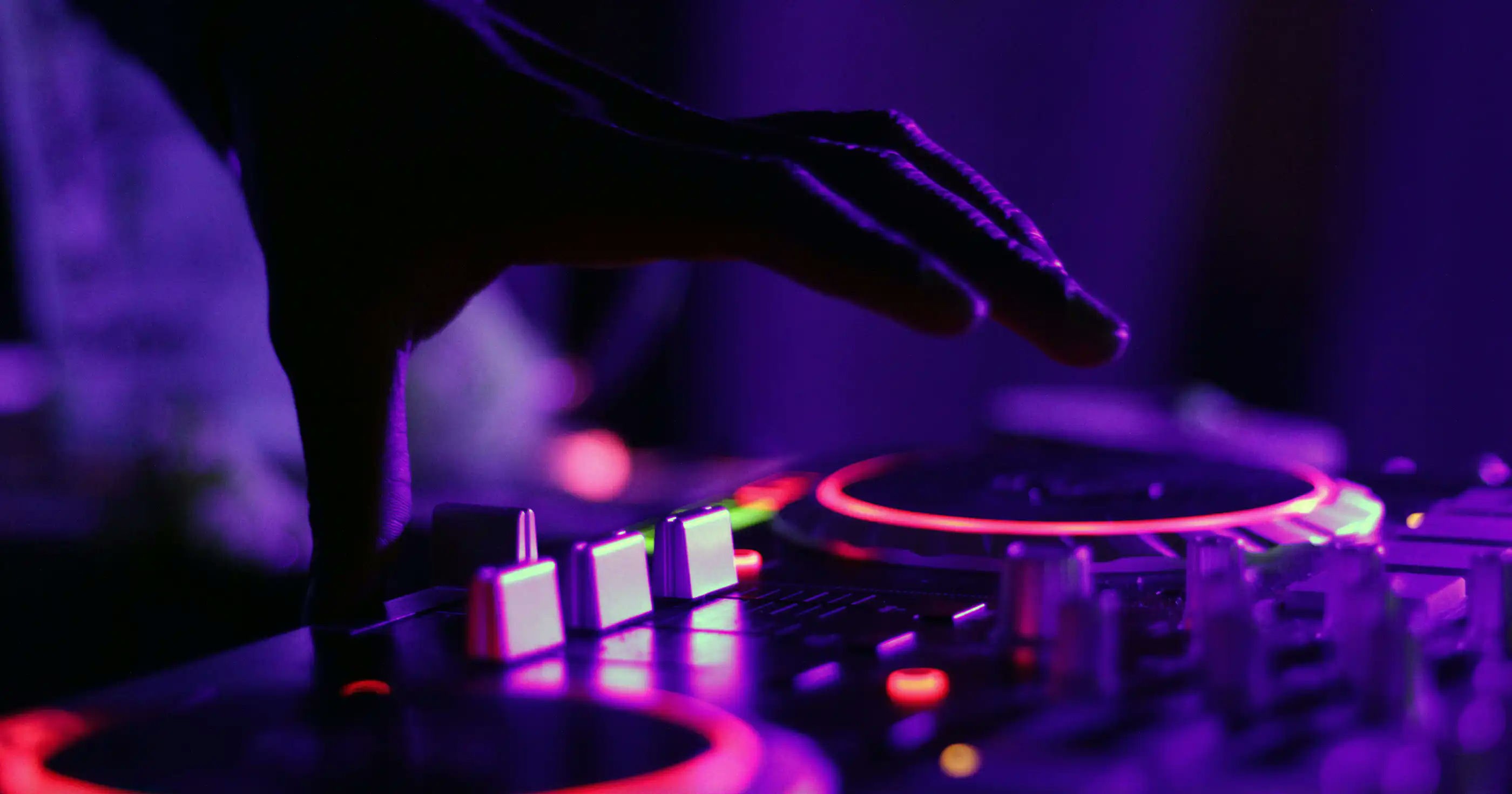 A hand hovers over a dj mixing board