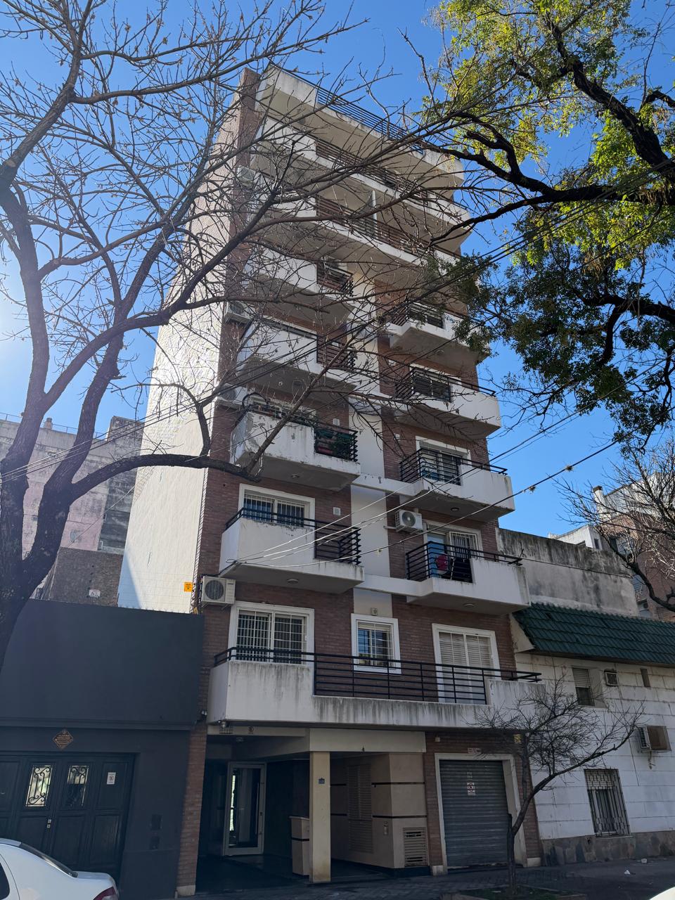 Edificio de departamentos con ladrillo visto y revestimiento blanco, balcones con rejas de hierro, Edificio Kaihi, Rosario