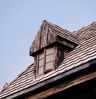 Weathered wooden dormer roof before restoration