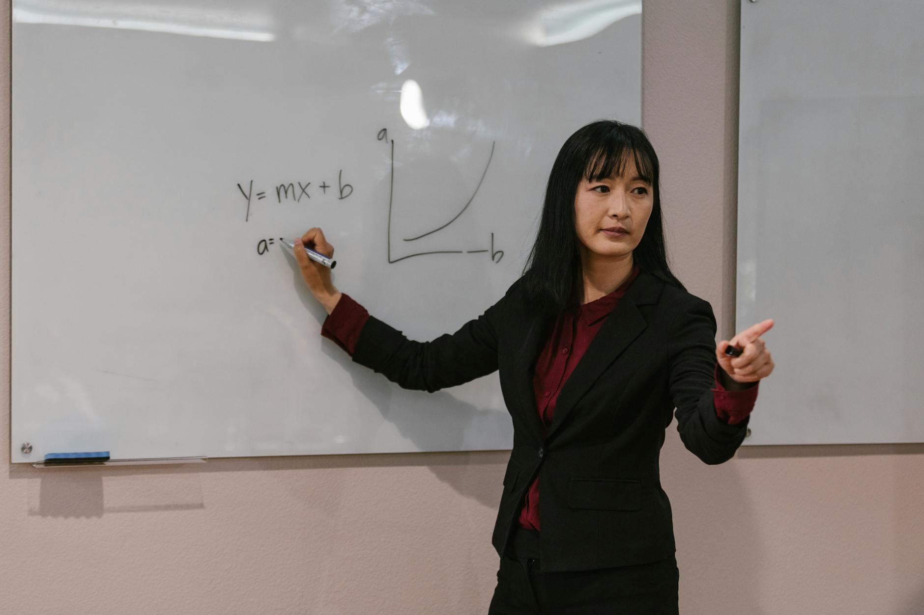 A music professor pointing to an anatomical diagram of the human larynx while explaining vocal pedagogy principles.
