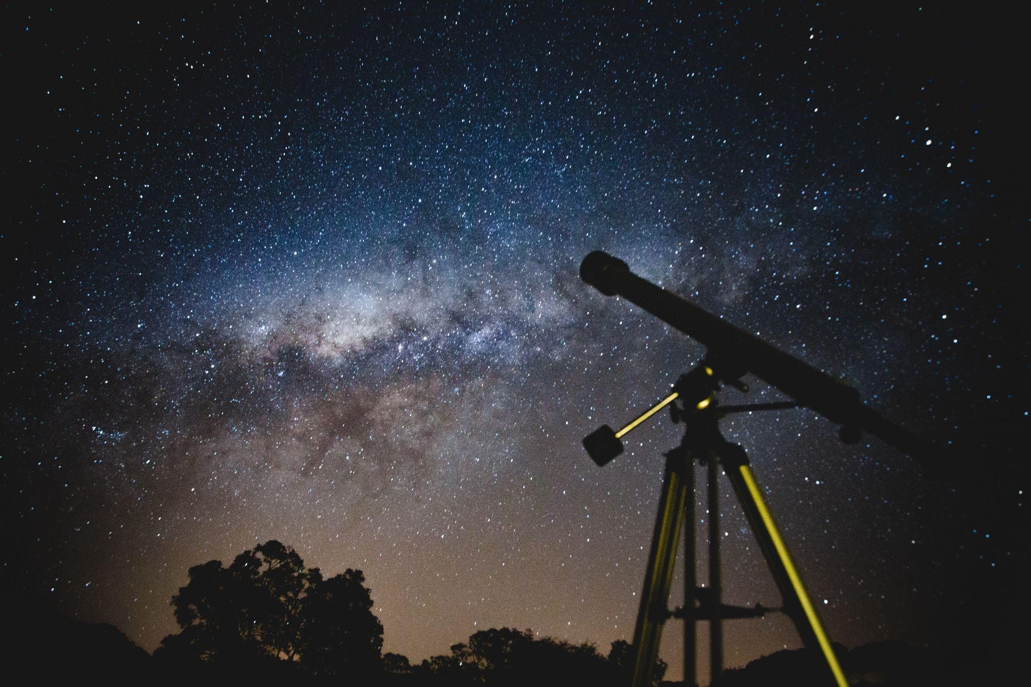 Telescope under the a starry night sky
