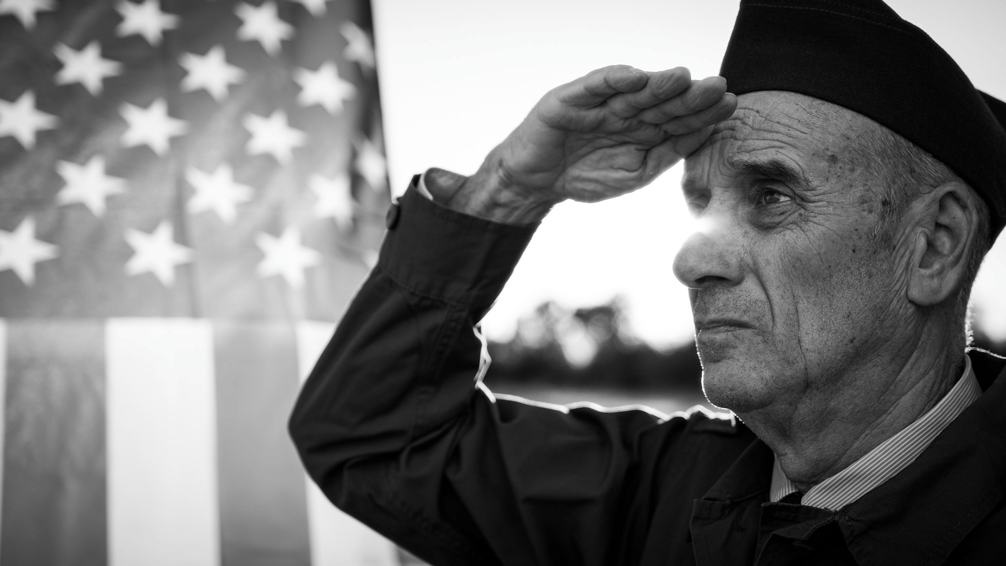 Veteran saluting in front of American flag