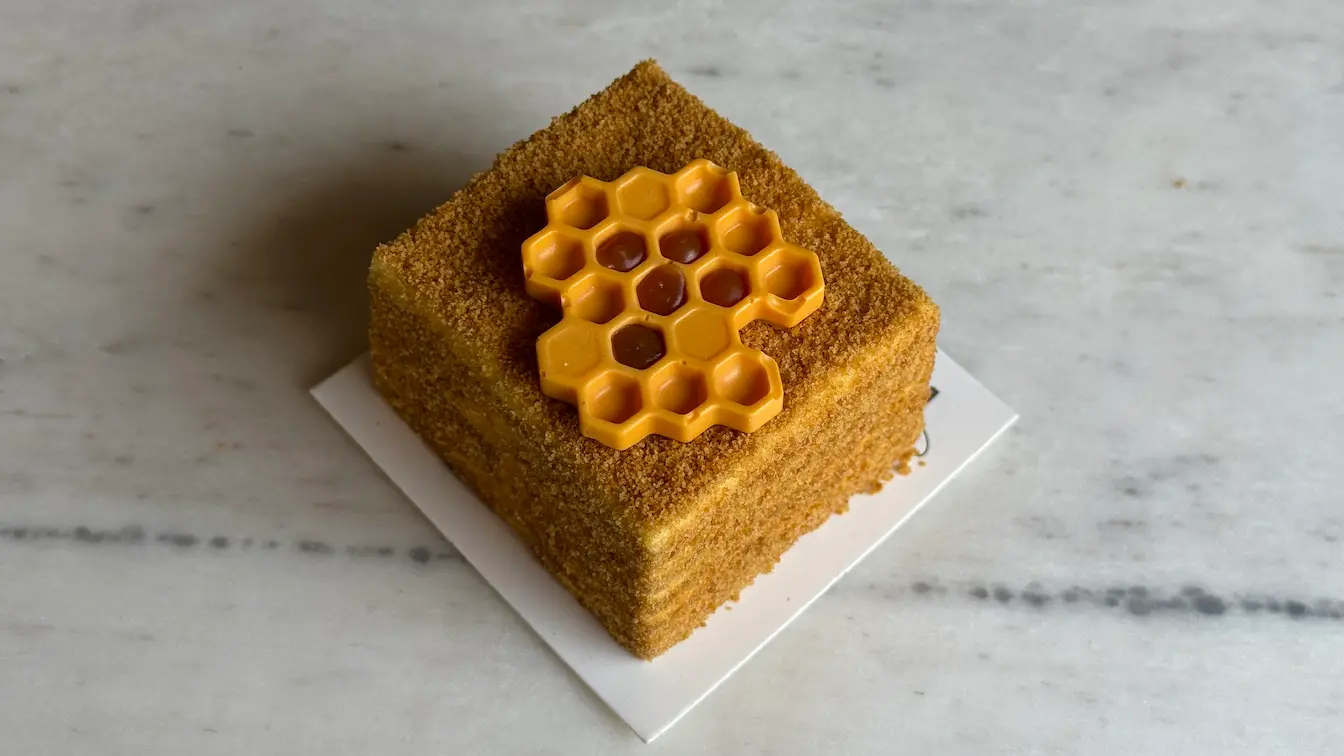 Honey cake square topped with honeycomb chocolate decoration