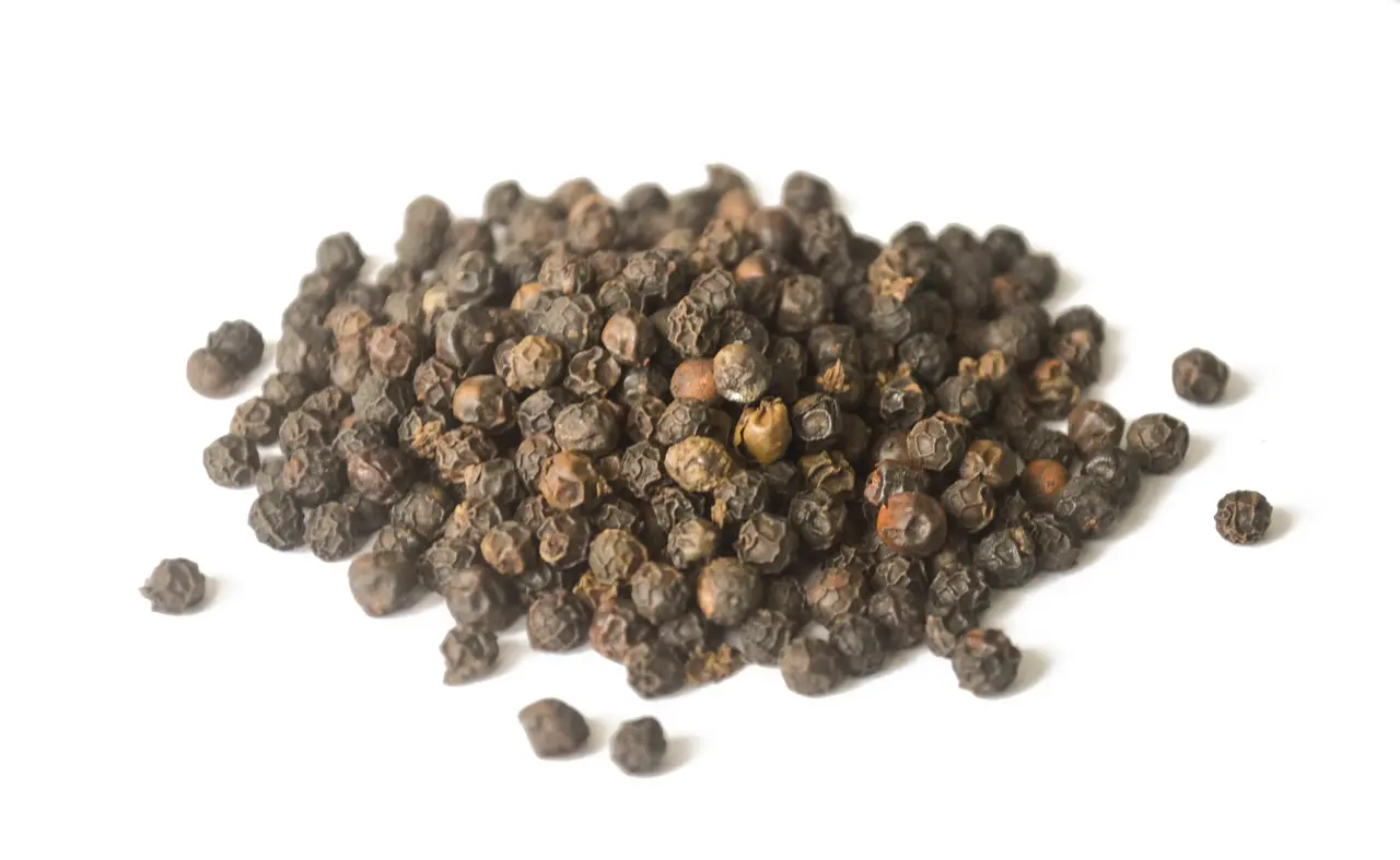 Rozsypany pieprz na białym tle.