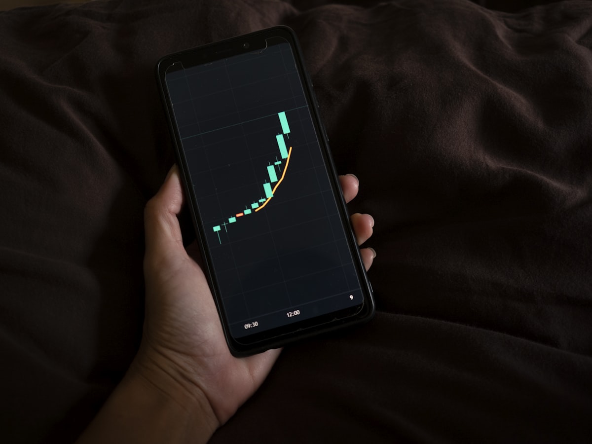 Phone showing a flight price tracker graph for finding cheap flights