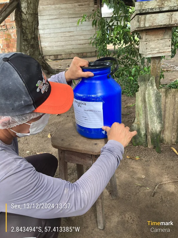 Homem manuseando galão de mel.