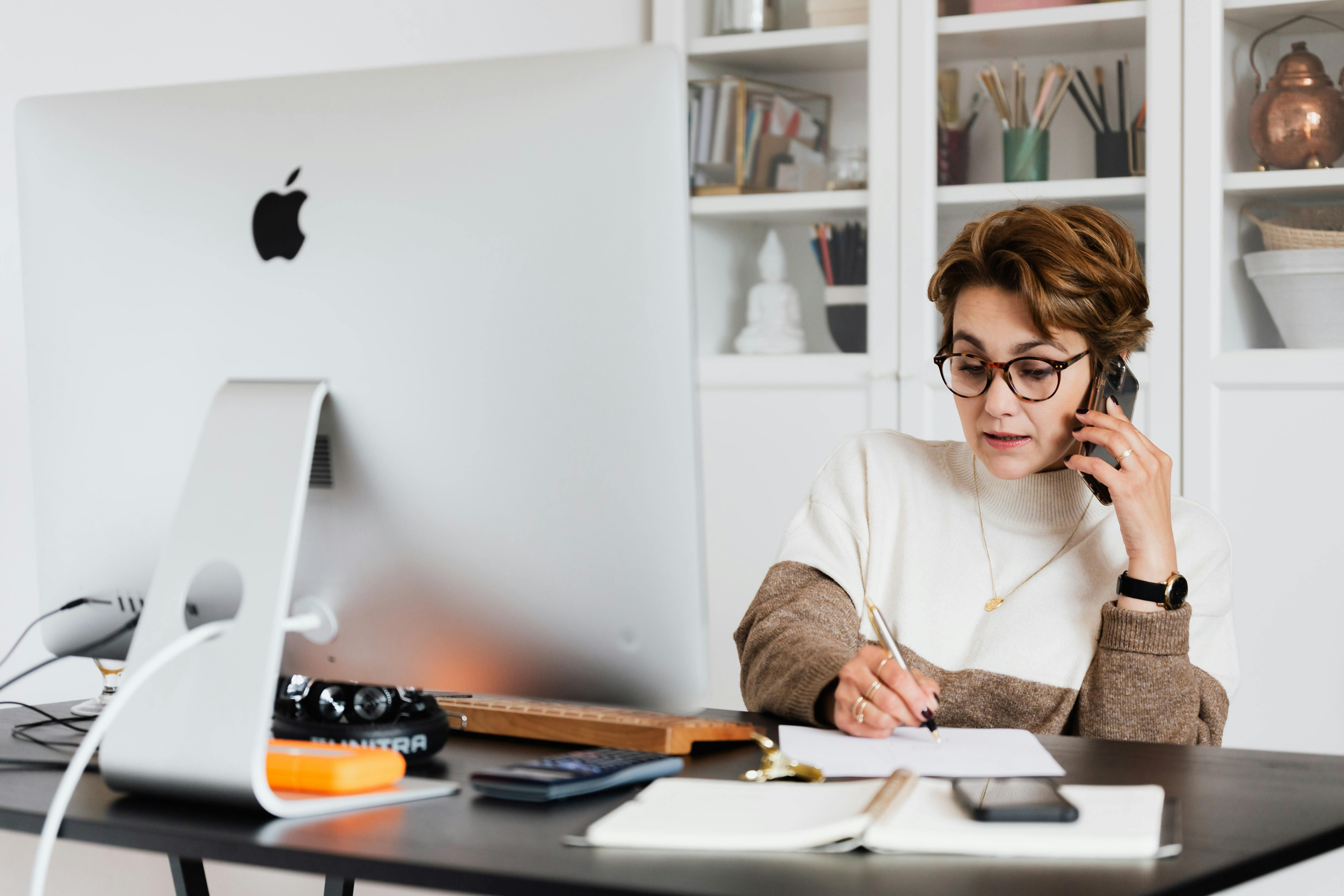 Closeup of woman wearing gold sweater typing on MacBook Pro