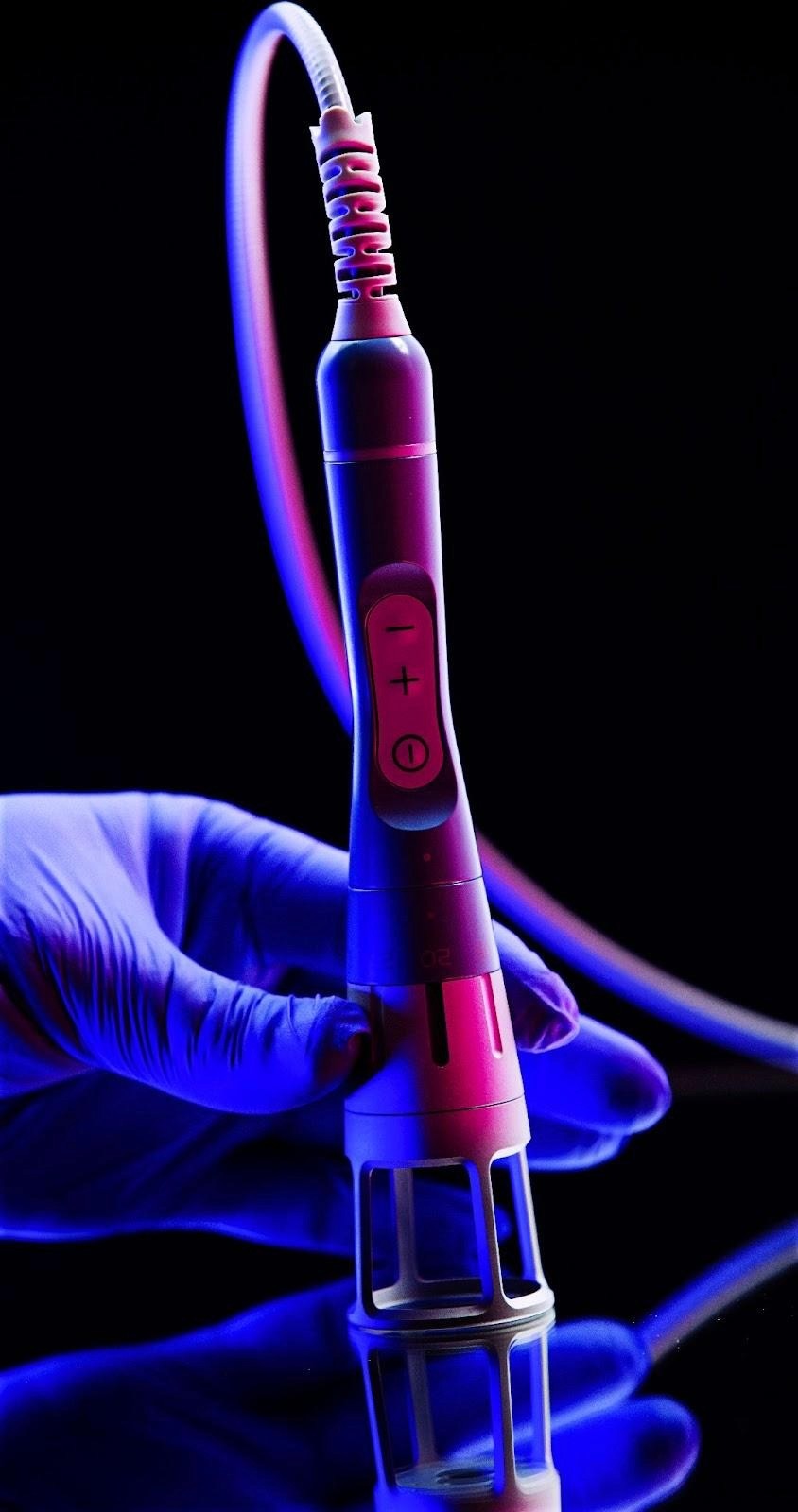 A person in blue gloves holds a device, symbolizing innovative functional wellness treatments at My Dental Touch Wellness Studio.