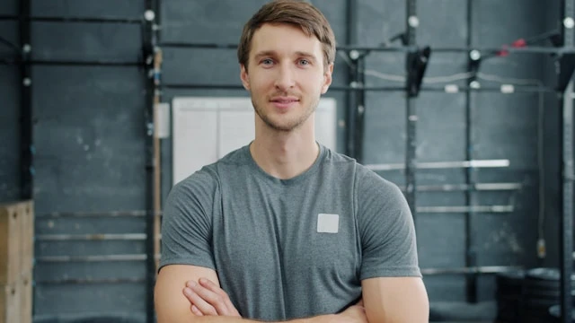 Portrait of a young man standing indoors in a gym setting