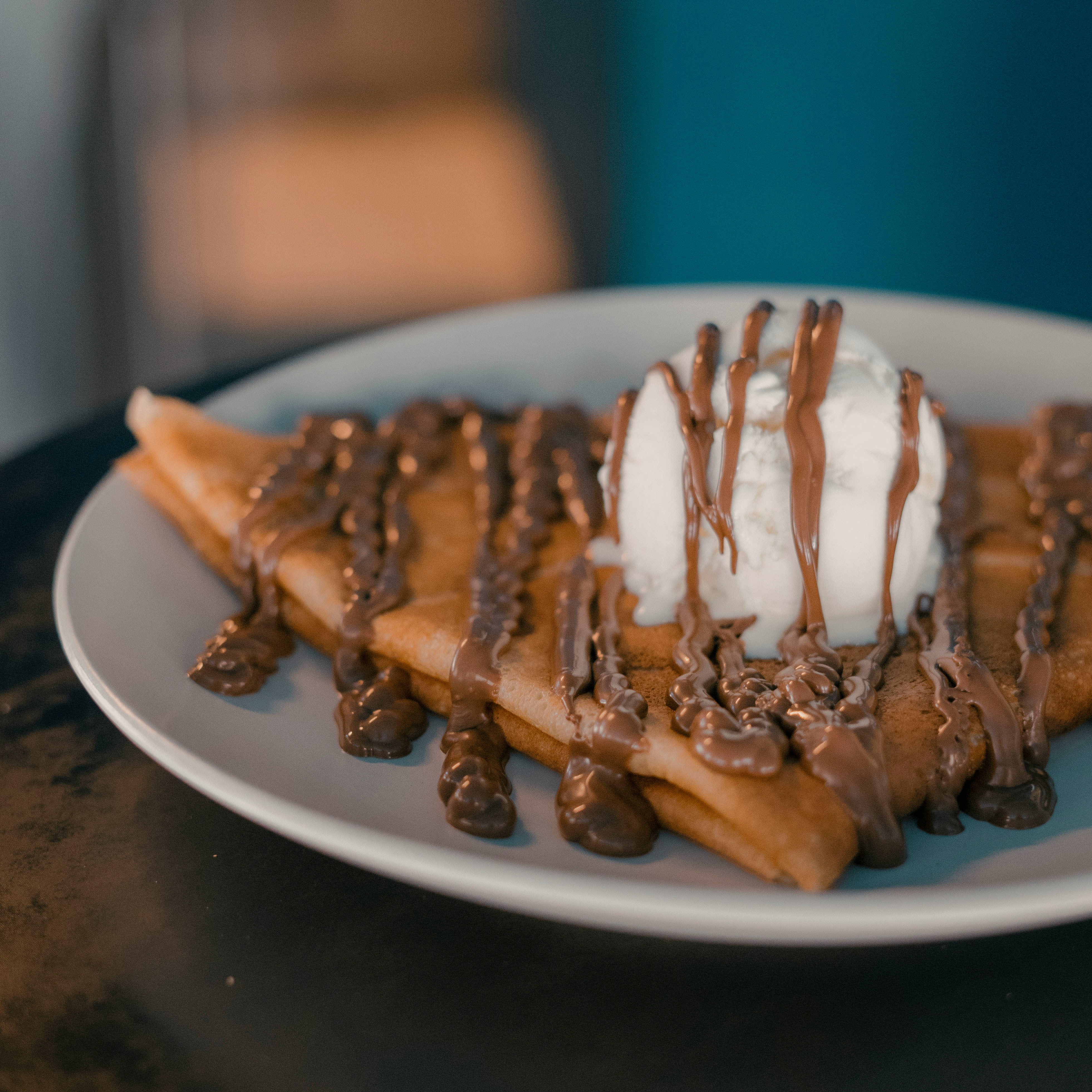 Crepe served with ice cream and chocolate drizzle.