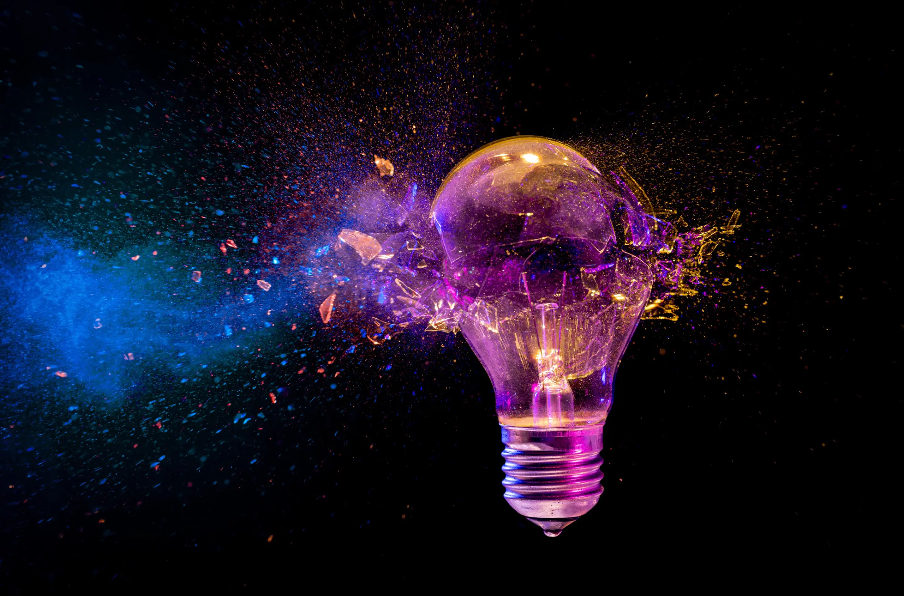 Exploding light bulb with colourful burst representing disruptive innovation and creative breakthrough