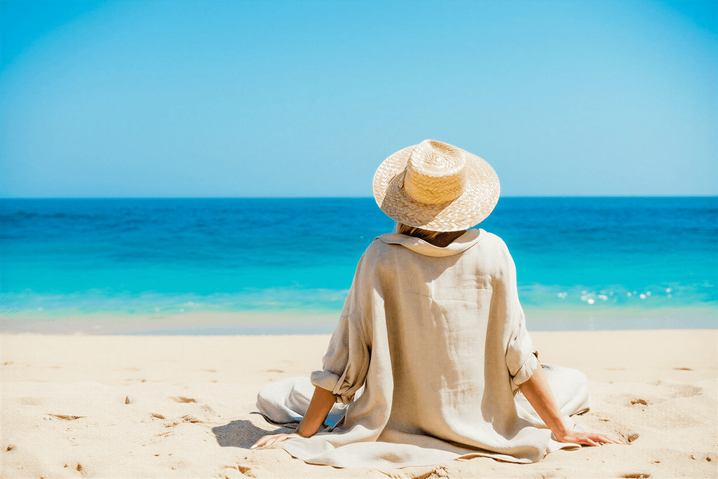 Kvinna på RE:YOU hälsoretreat, sitter på stranden vid havet