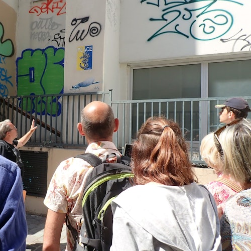 Guía e invitados contemplando arte urbano