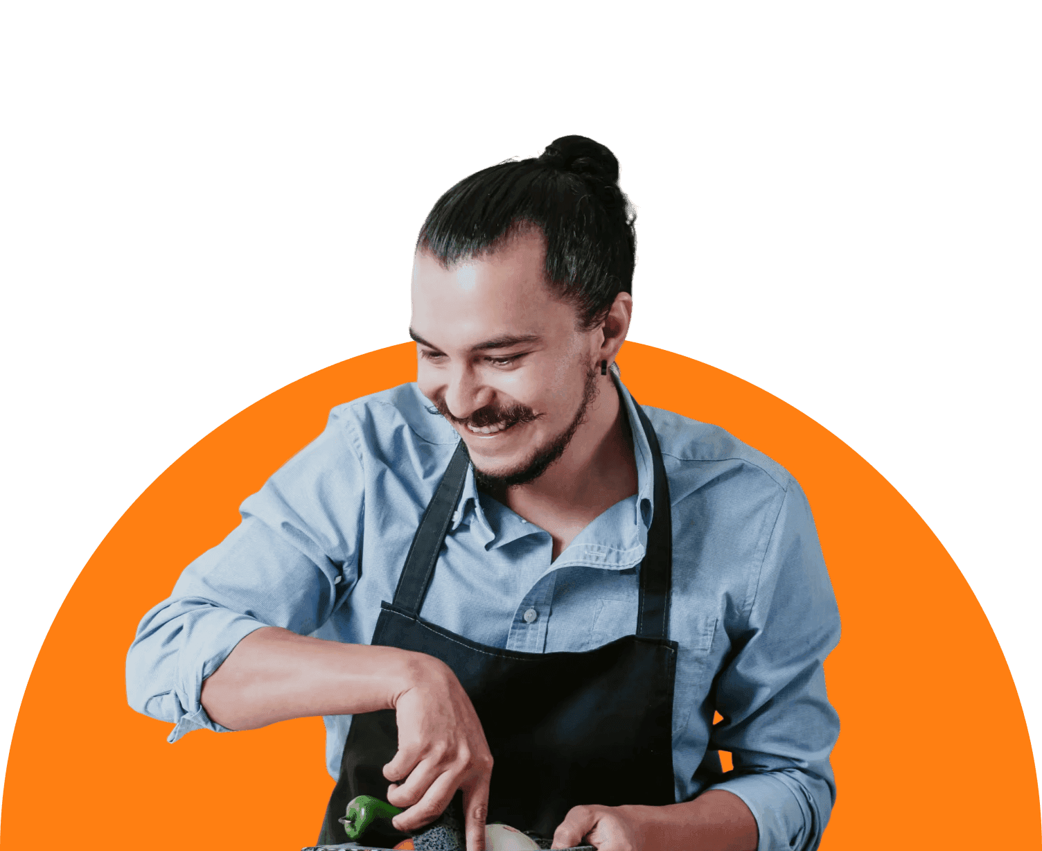 A smiling man in an apron chops ingredients on a cutting board, radiating joy and enthusiasm in the kitchen.