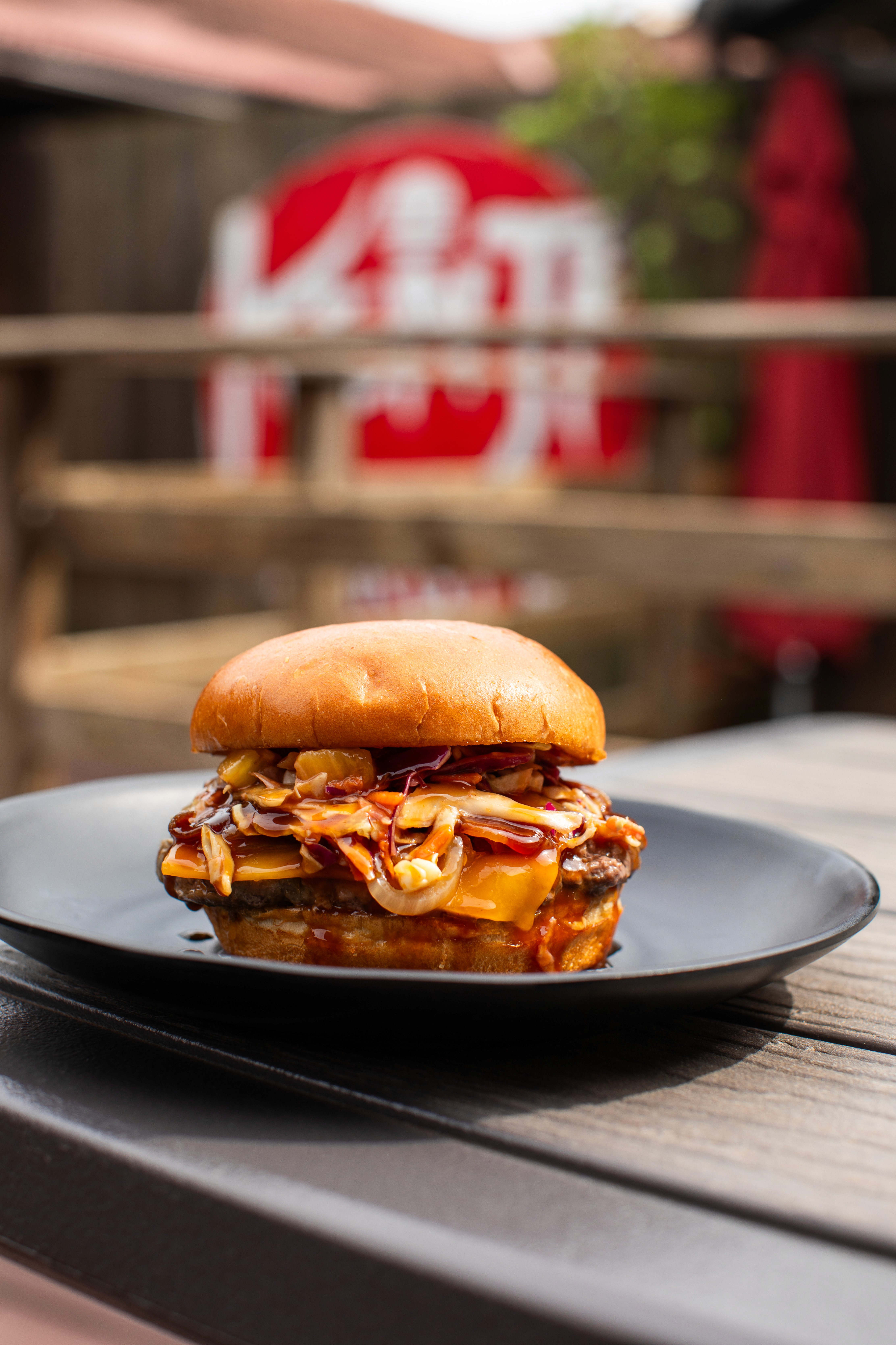 A plate of five savory soft-shell tacos, generously filled with seasoned meat, cilantro, and shredded cheese, presented in a dimly lit, atmospheric setting with a lit candle and a copper vessel in the background.