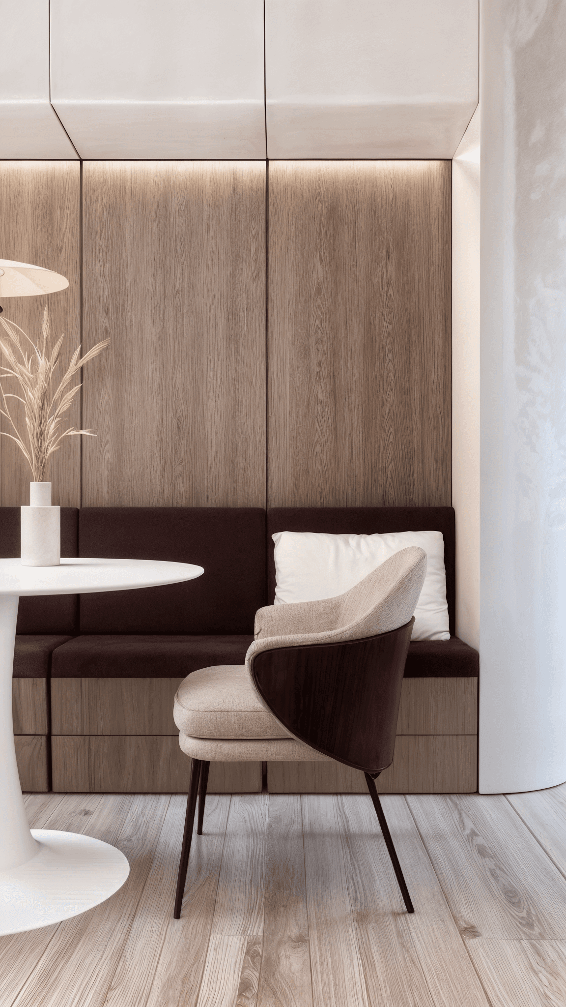 Compact interieur met houten wandafwerking, ingebouwde zitbank en fauteuil in zachte, natuurlijke tinten.