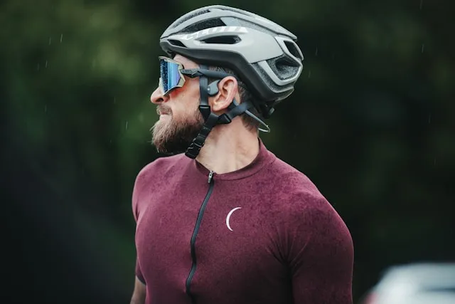 Cyclist wearing a helmet and sunglasses looking ahead during an outdoor ride