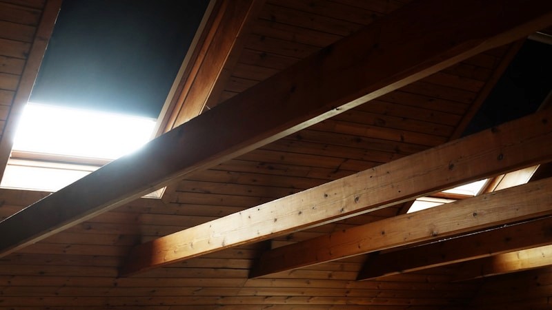 Specialist removing spray foam insulation from loft roof timbers