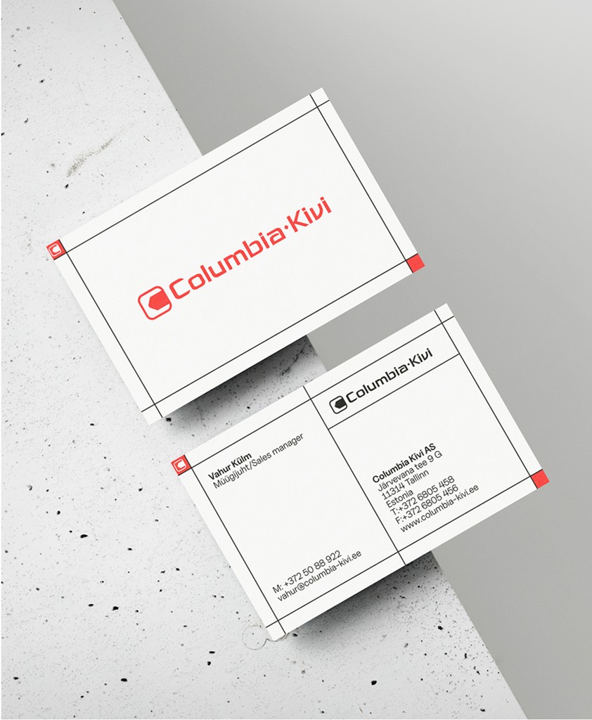 Two business cards placed on a concrete table. Cards are half eay over the edge.