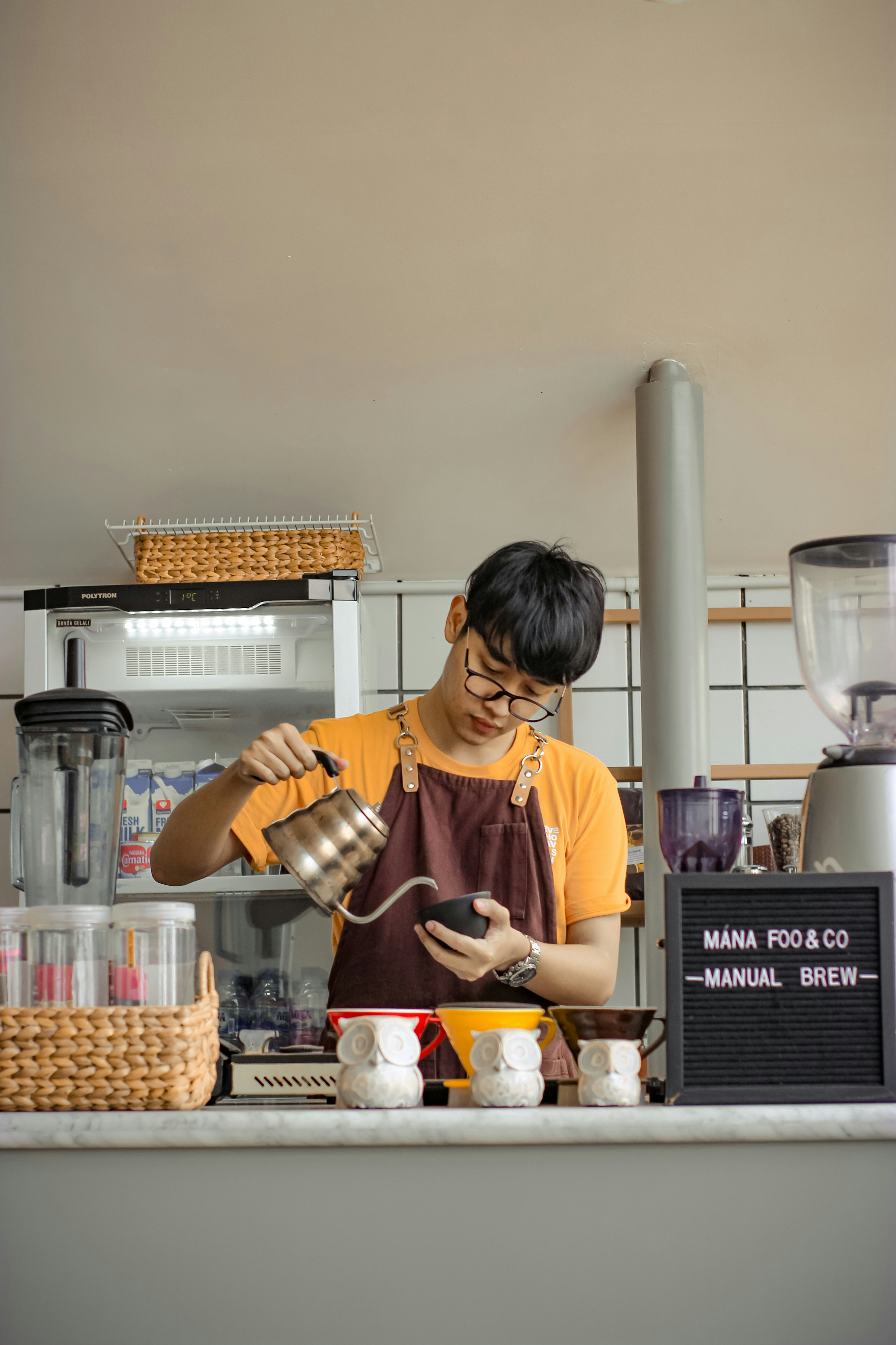 Barista in cafe pouring coffee