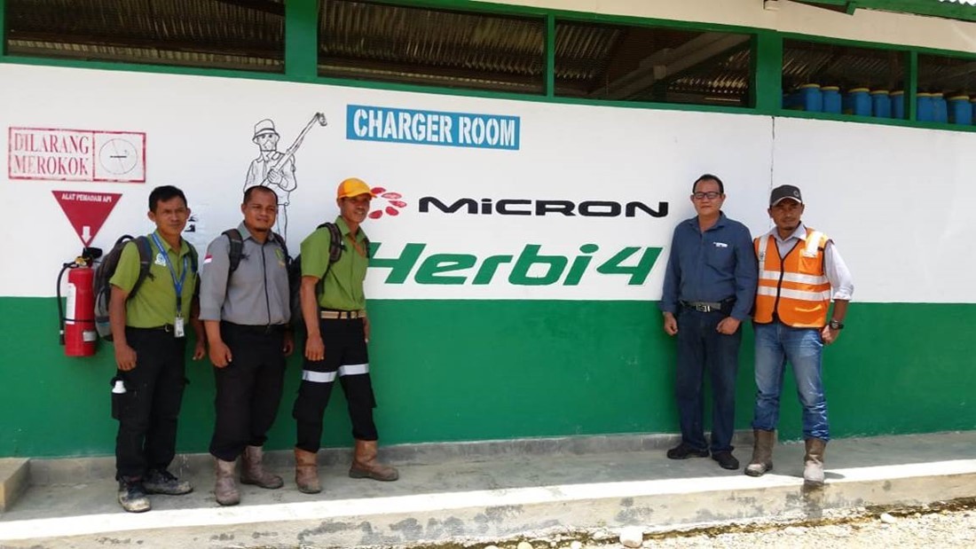 Black futuristic car in front of a modern building with glass front