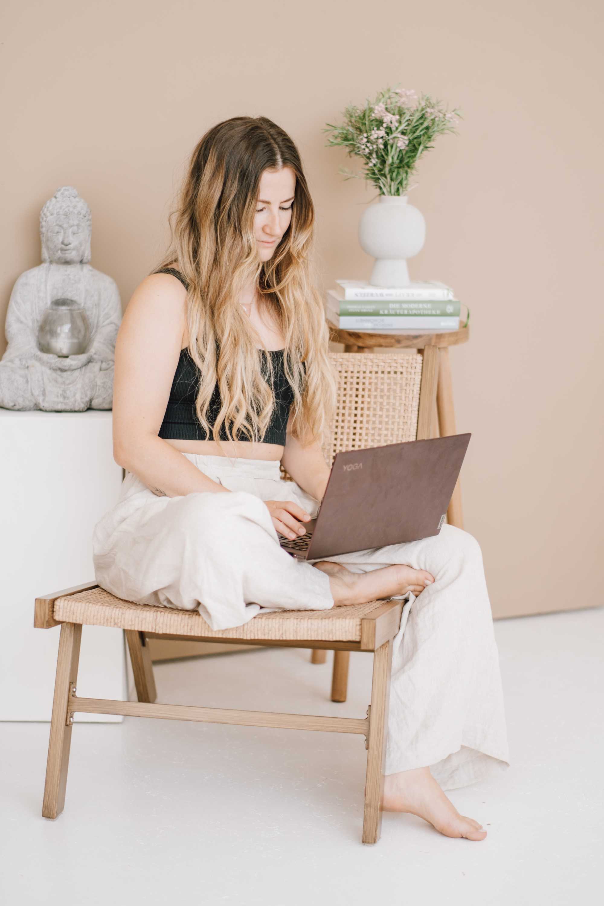 Ernährungsberaterin sitzt gemütlich auf einem Stuhl mit dem Laptop auf dem Schoß