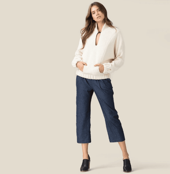 Woman Crossing Zebra Crossing Against Yellow Wall