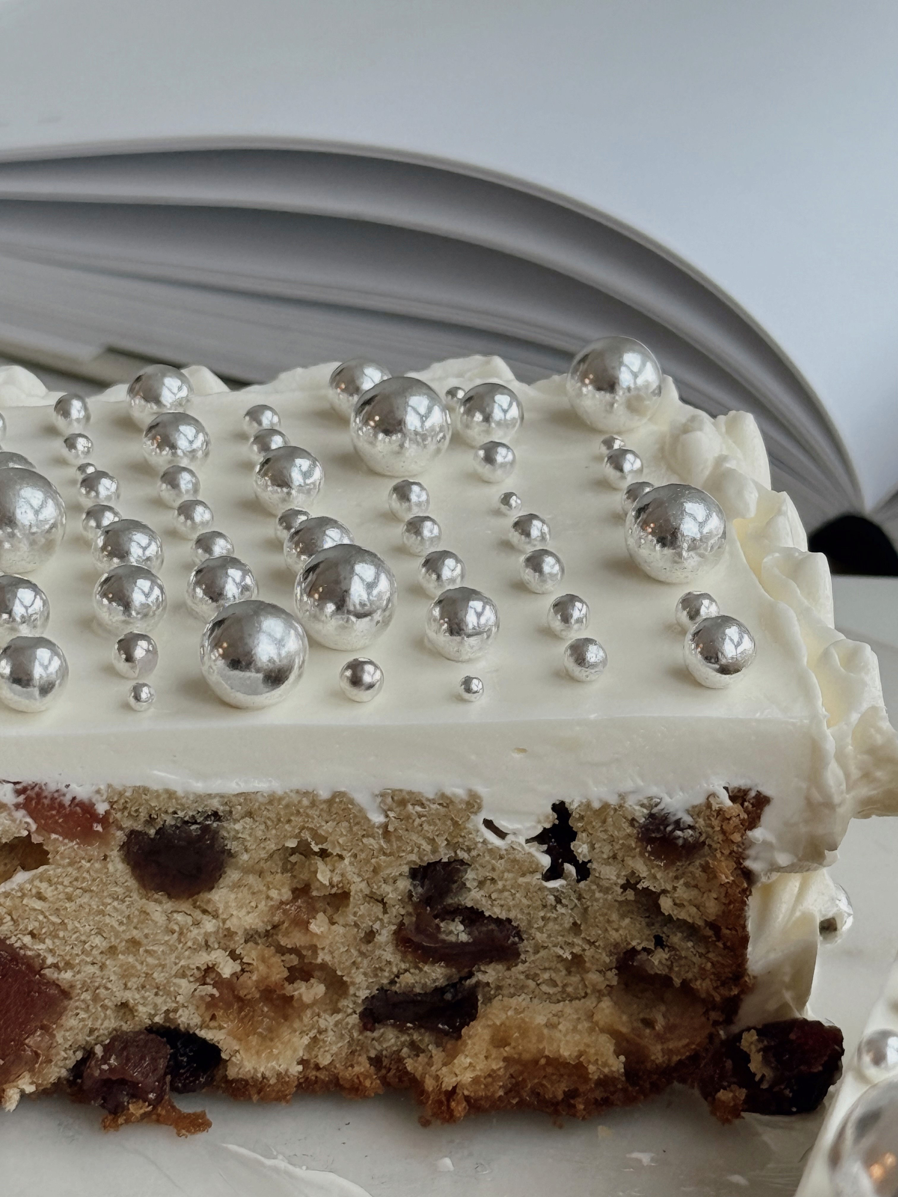 Minimalist white buttercream cake topped with clear sugar spheres
