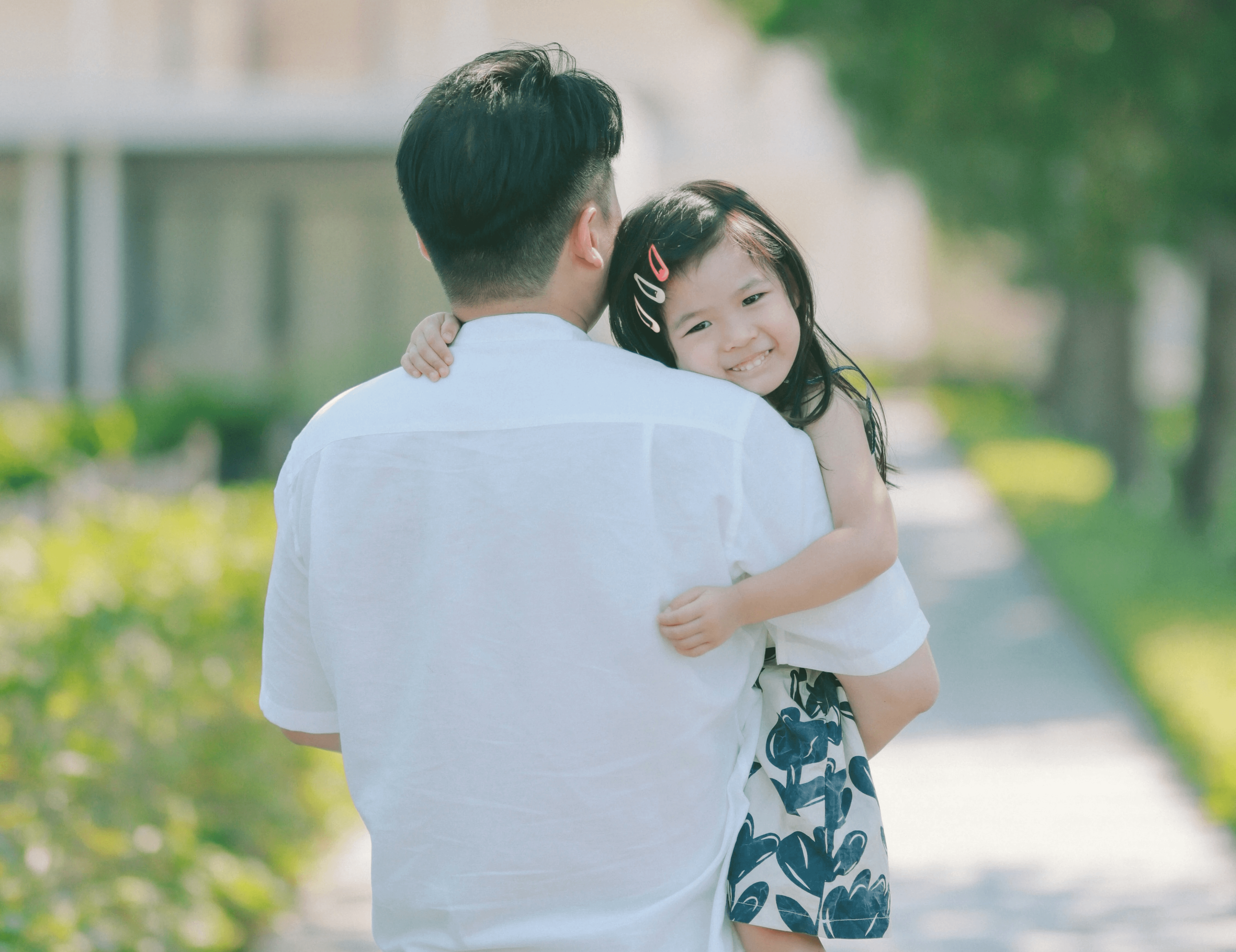 Man holding young girl, who is smiling at the camera
