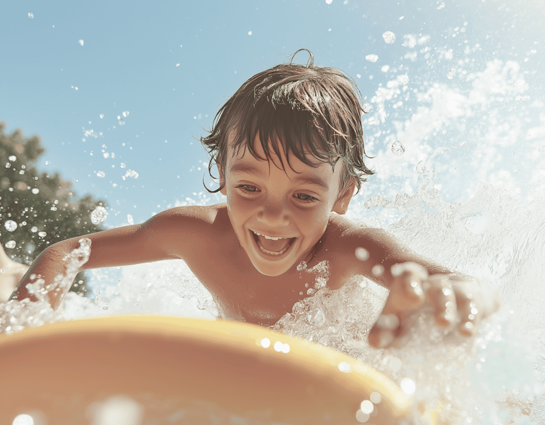 A joyful child splashing in the water while reaching for a yellow float.
