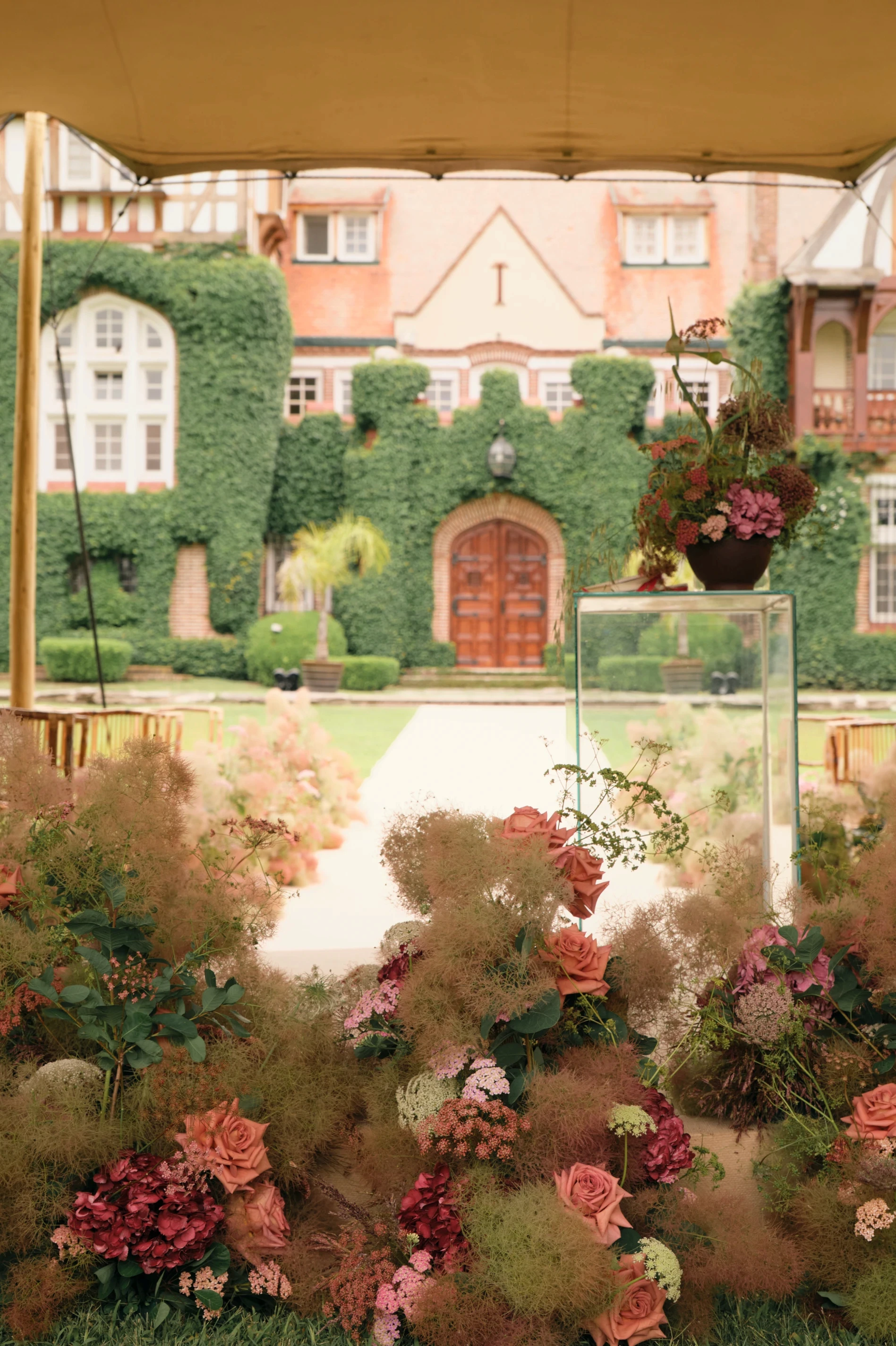 Vista desde el altar hacia la arquitectura de Villa María con arreglos de rosas y follaje etéreo en primer plano.