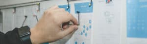person working on blue and white paper on board