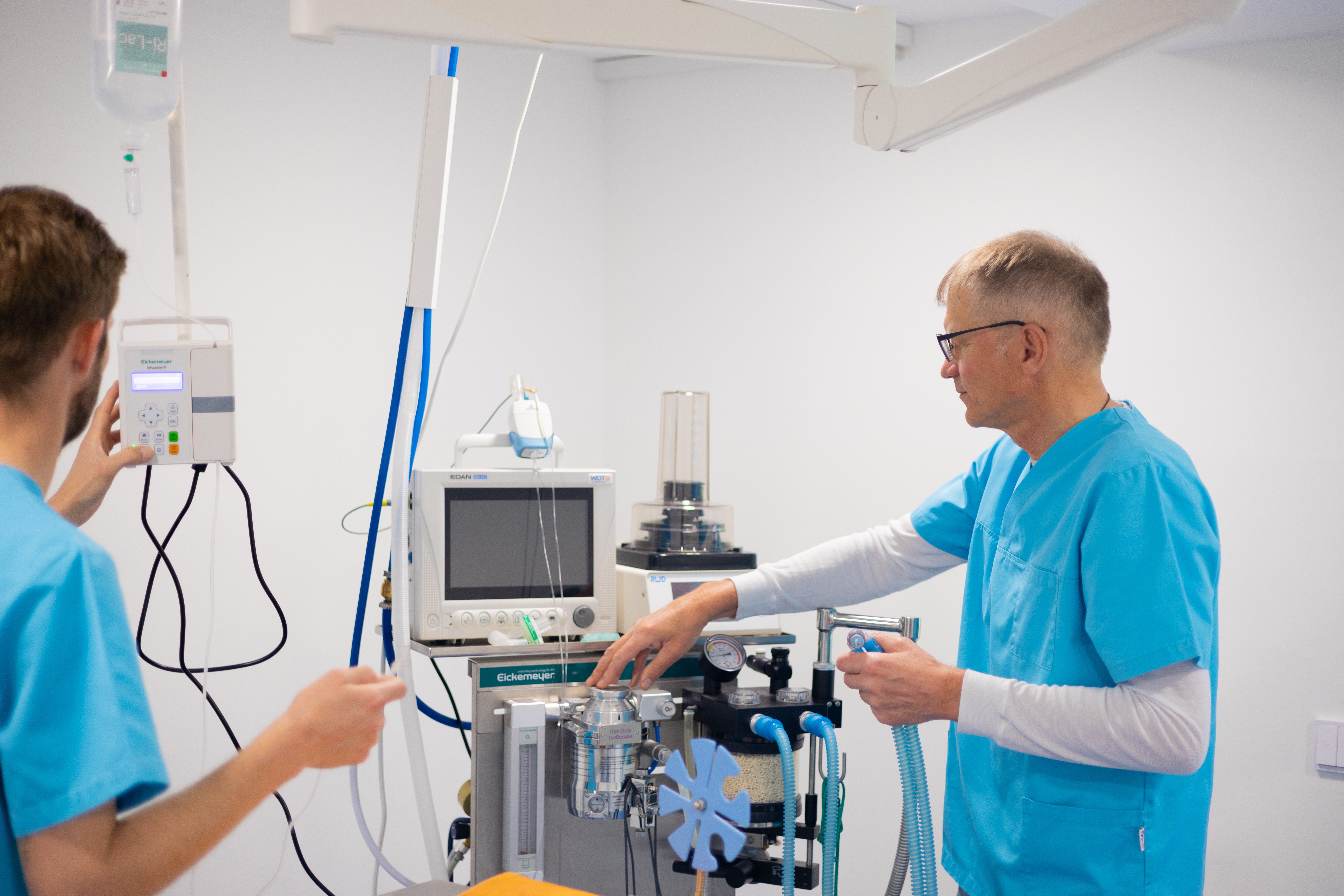 Ein Tierarzt in blauer Kleidung arbeitet in einer Tierarztpraxis an einem medizinischen Gerät