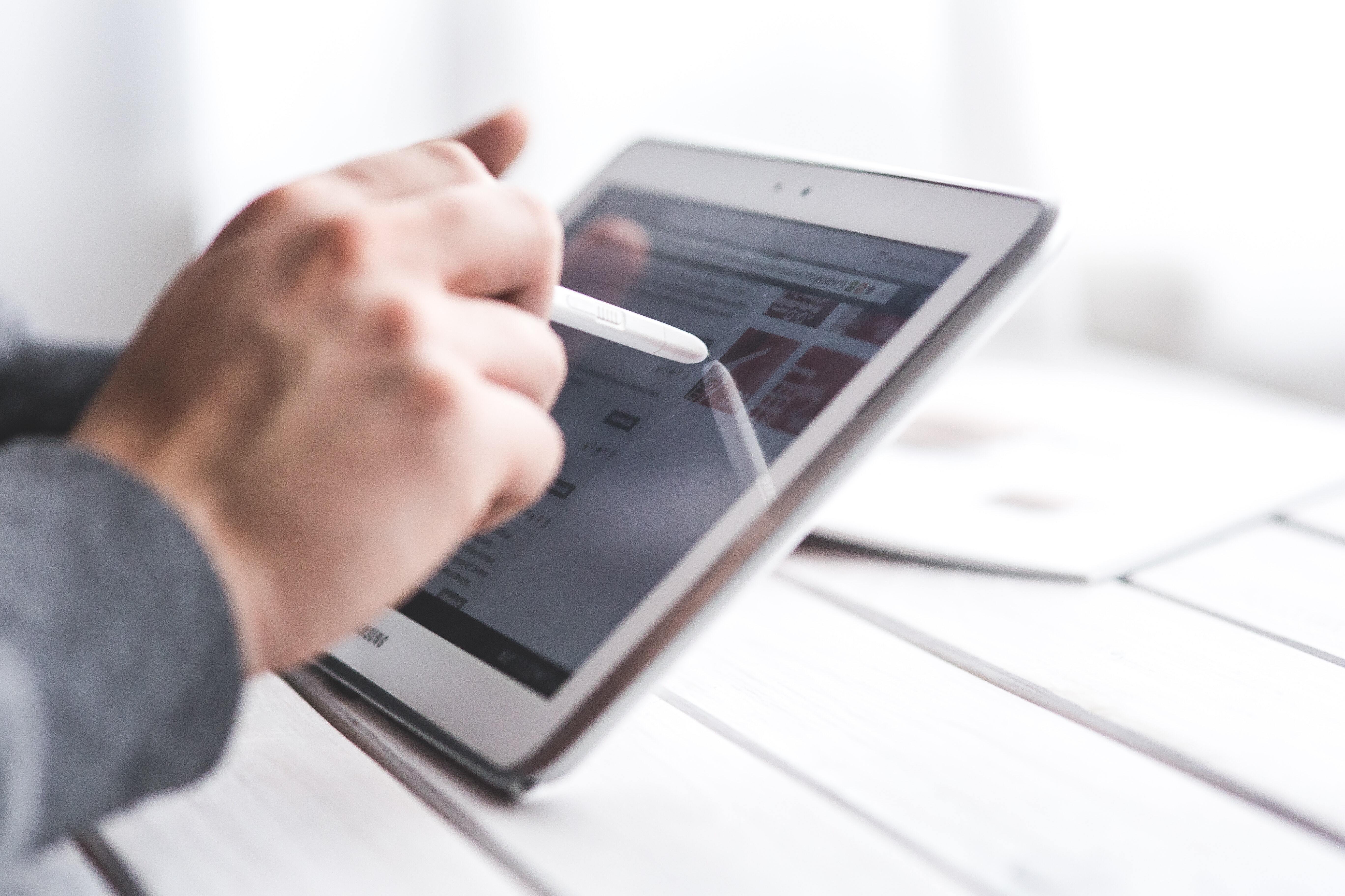 A man holding pointer and pointing at his tablet screen