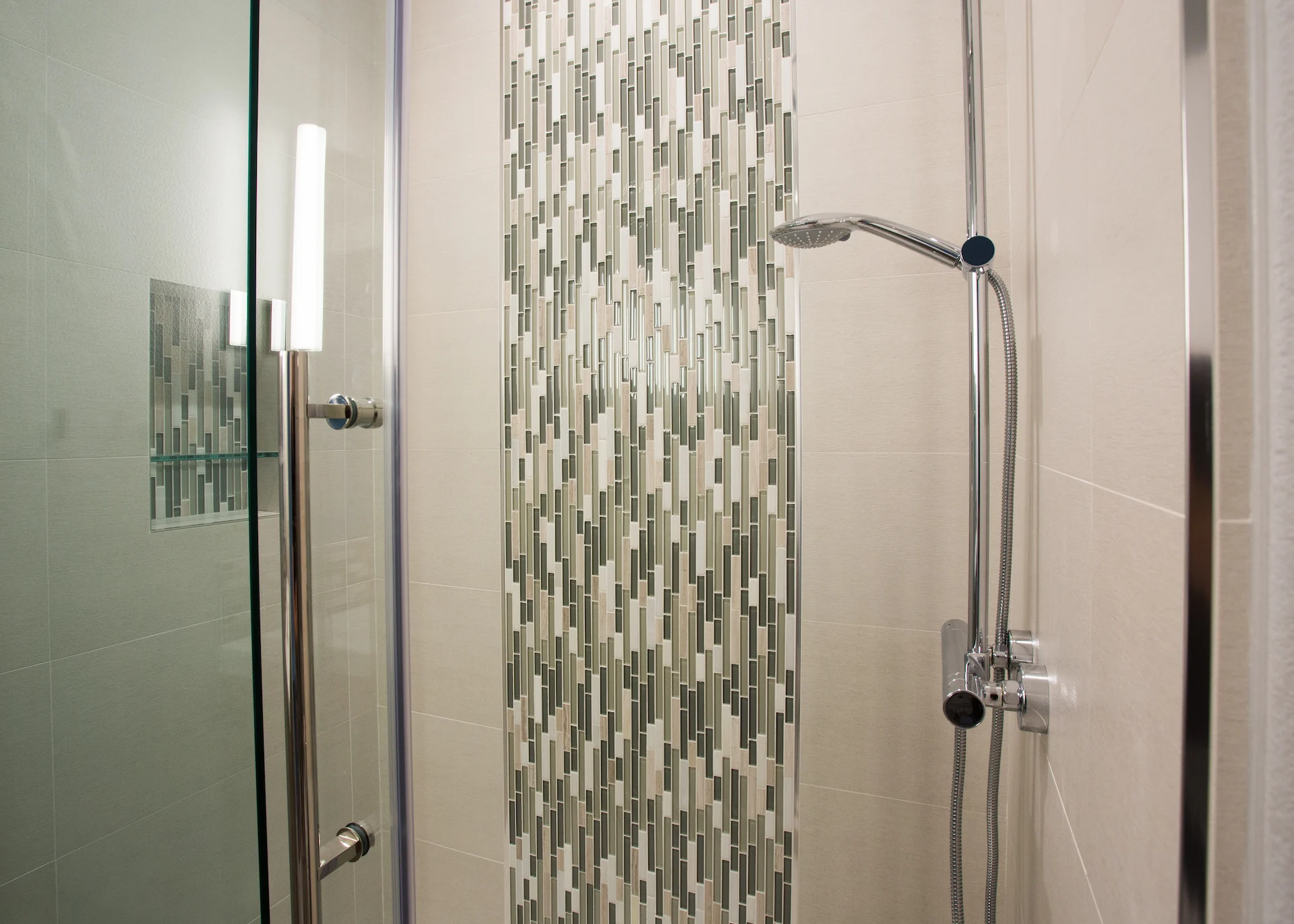 Close-up of the guest bathroom's shower fixtures, showcasing the contemporary design and quality materials in the Harbor Cove remodel.