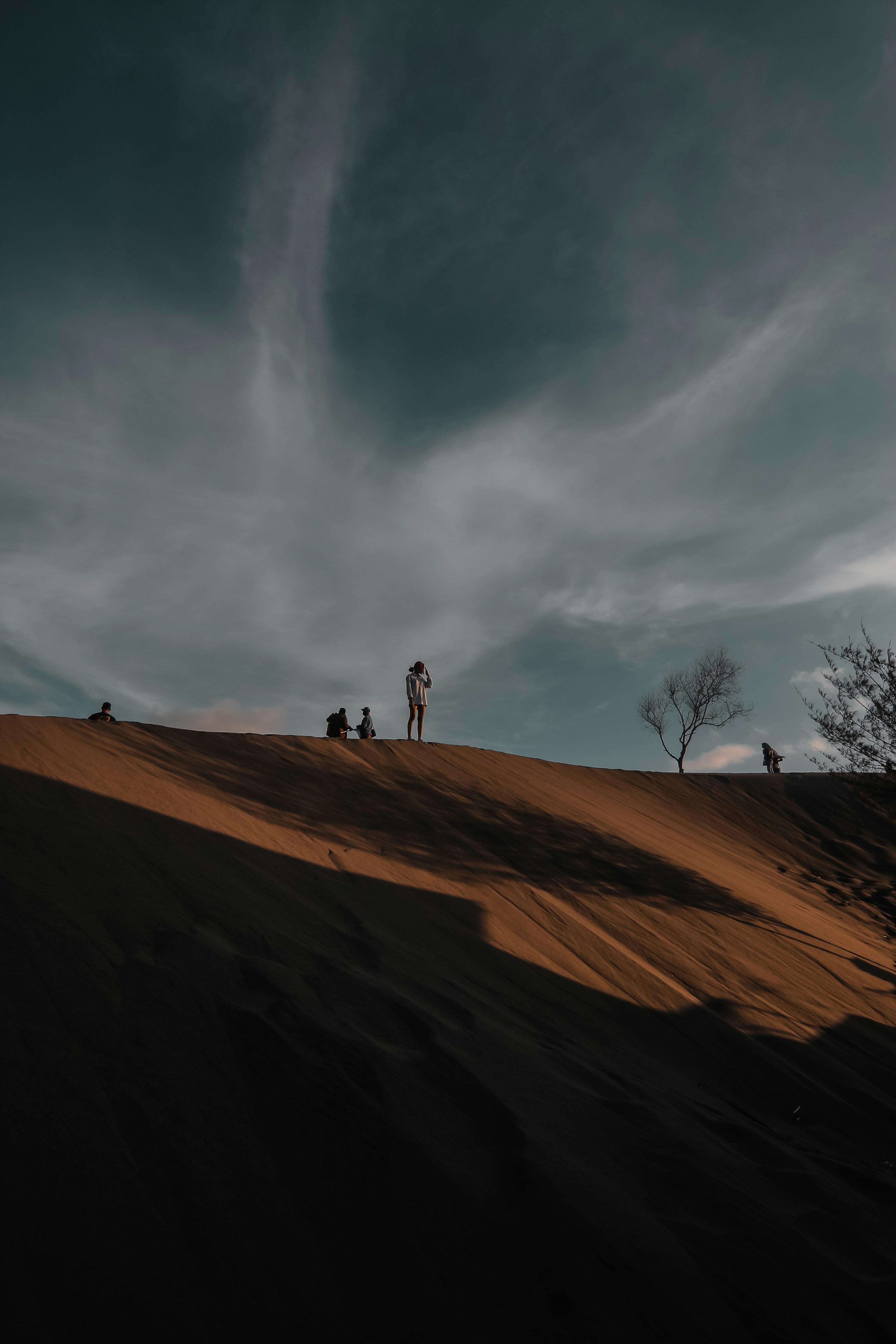 Person, die tagsüber auf braunem Sand unter blauem Himmel steht