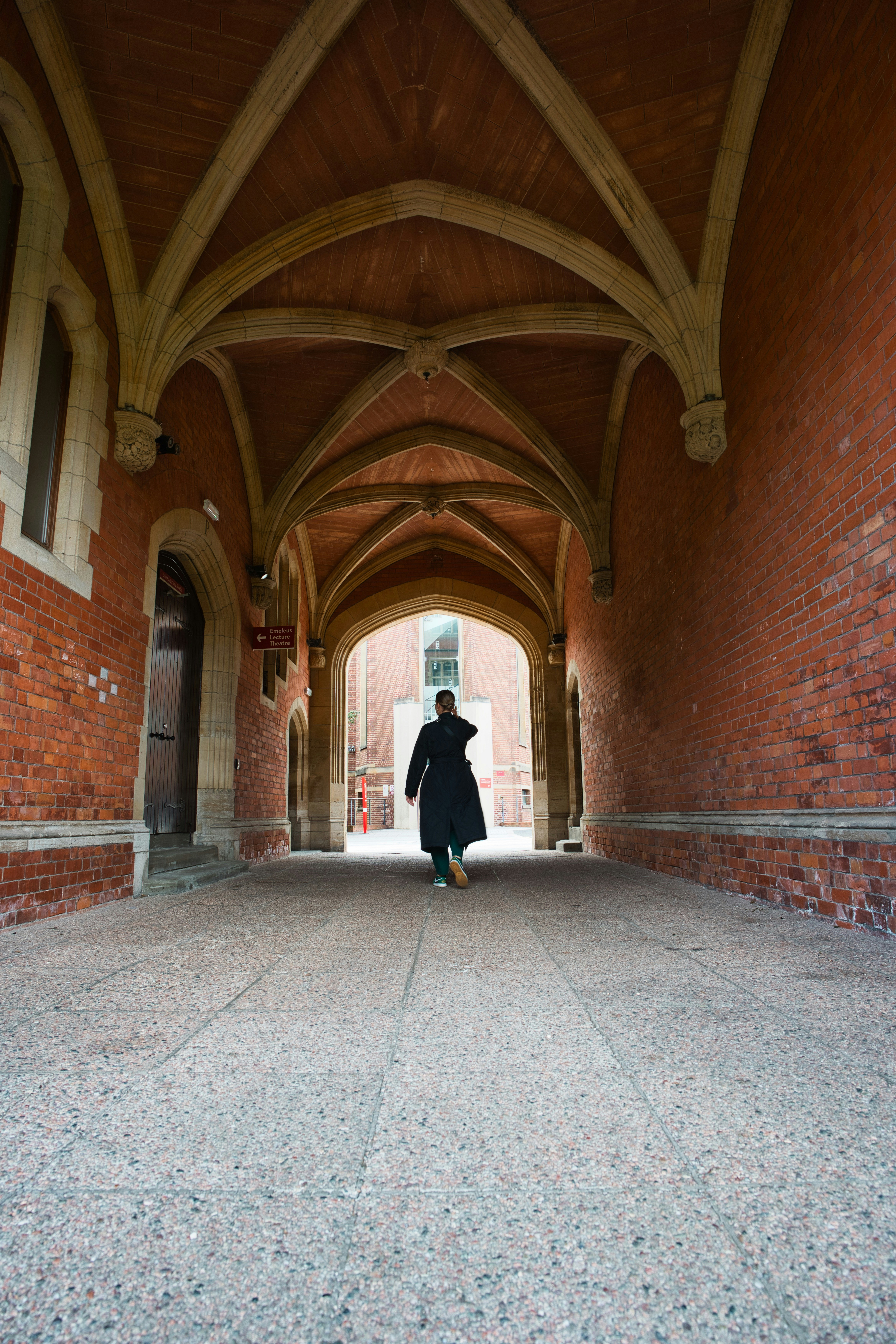 a person in a black coat is walking through a tunnel