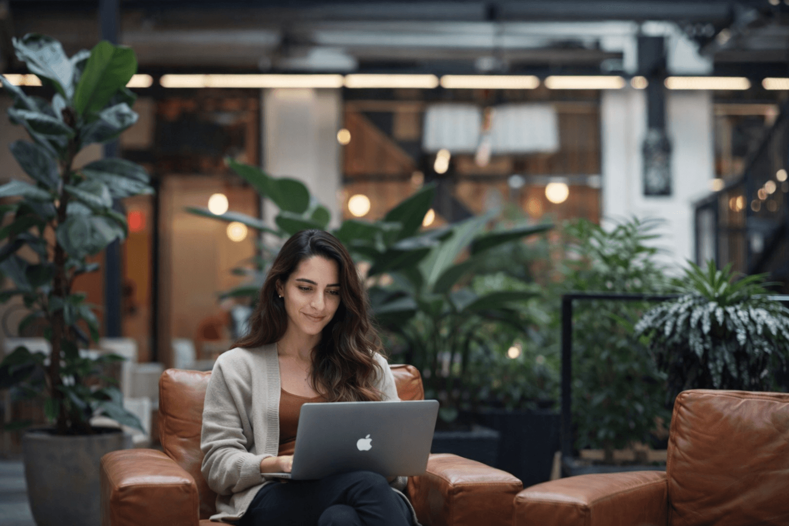 A group of four people engaged in a discussion while seated in a cozy, plant-filled setting.