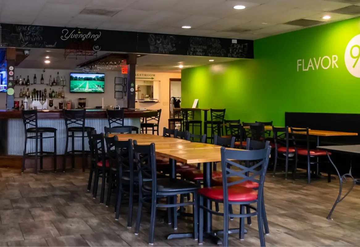 Dining room with bar and green wall at Flavor 91 Bistro