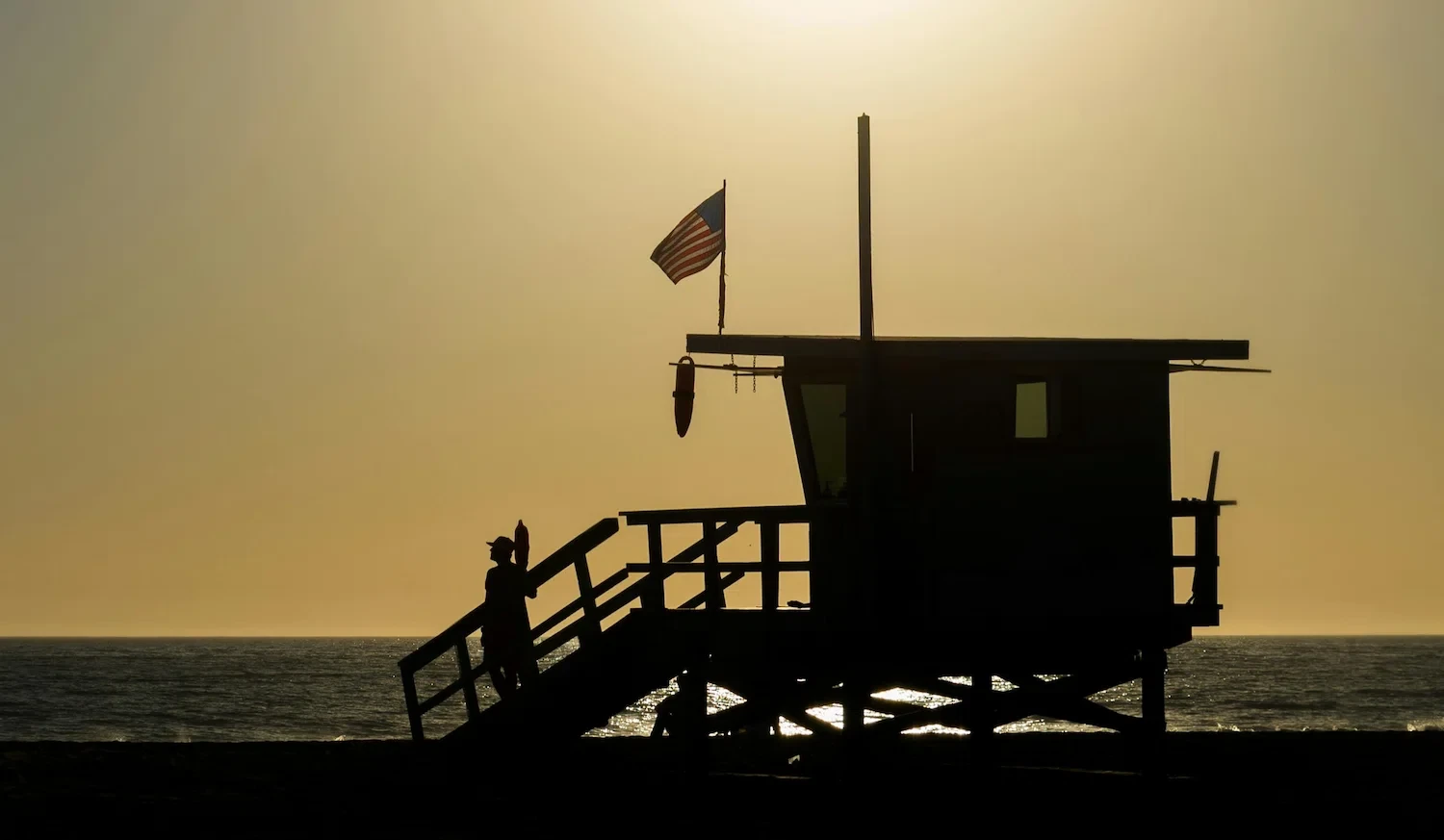 Lifeguard tower at sunset in Los Angeles representing calm balance and emotional healing through LGBTQ codependency therapy.