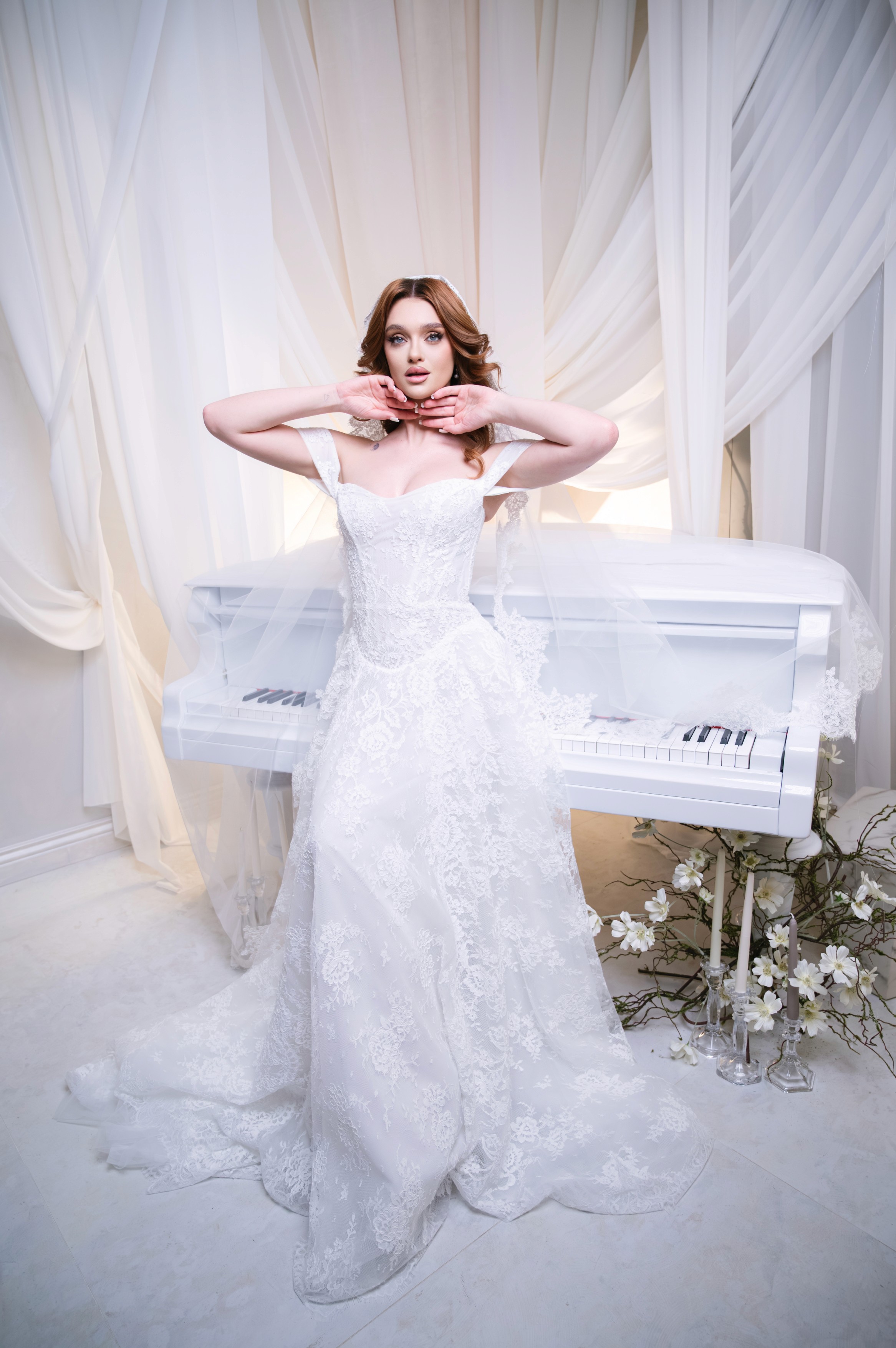 Mireasă pozând într-un decor luminos cu pian alb și voaluri, fotografie de nuntă în București
