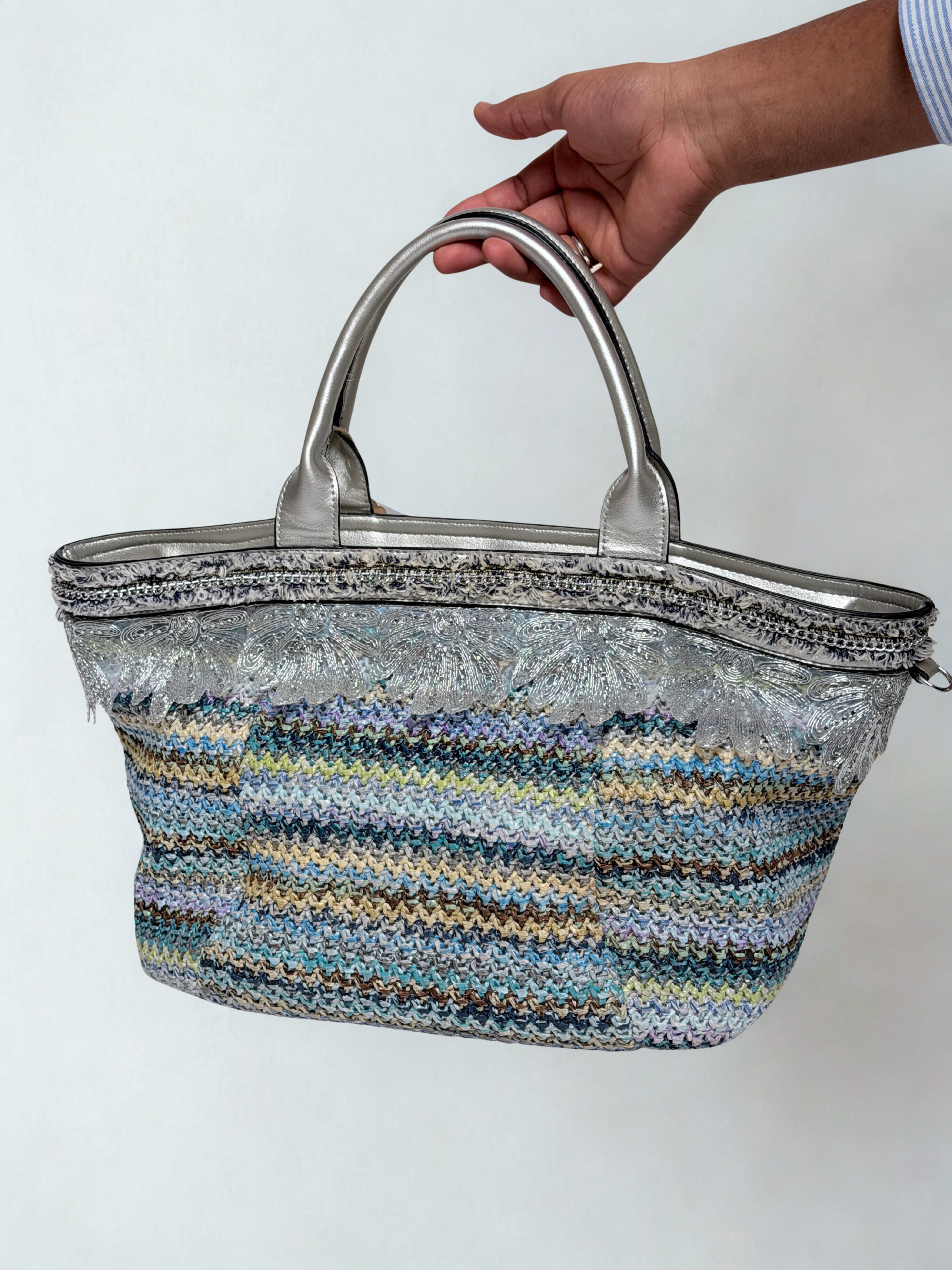Woven handbag held by a person