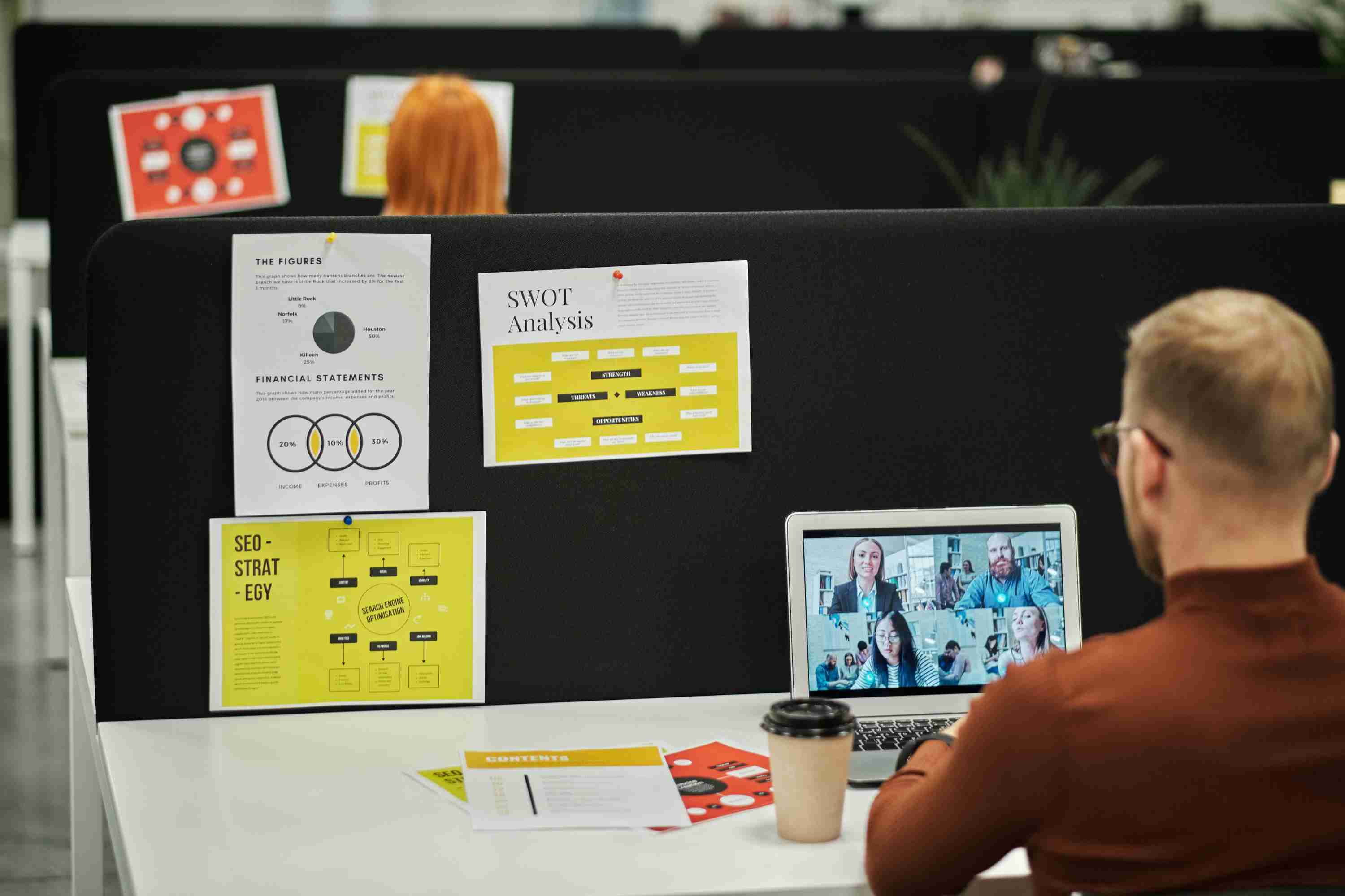 person in an office sitting on his desk watching a live webinar