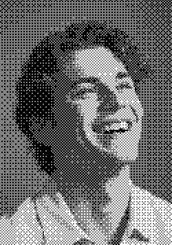 A smiling person with curly hair looks joyful, captured in a black-and-white portrait.