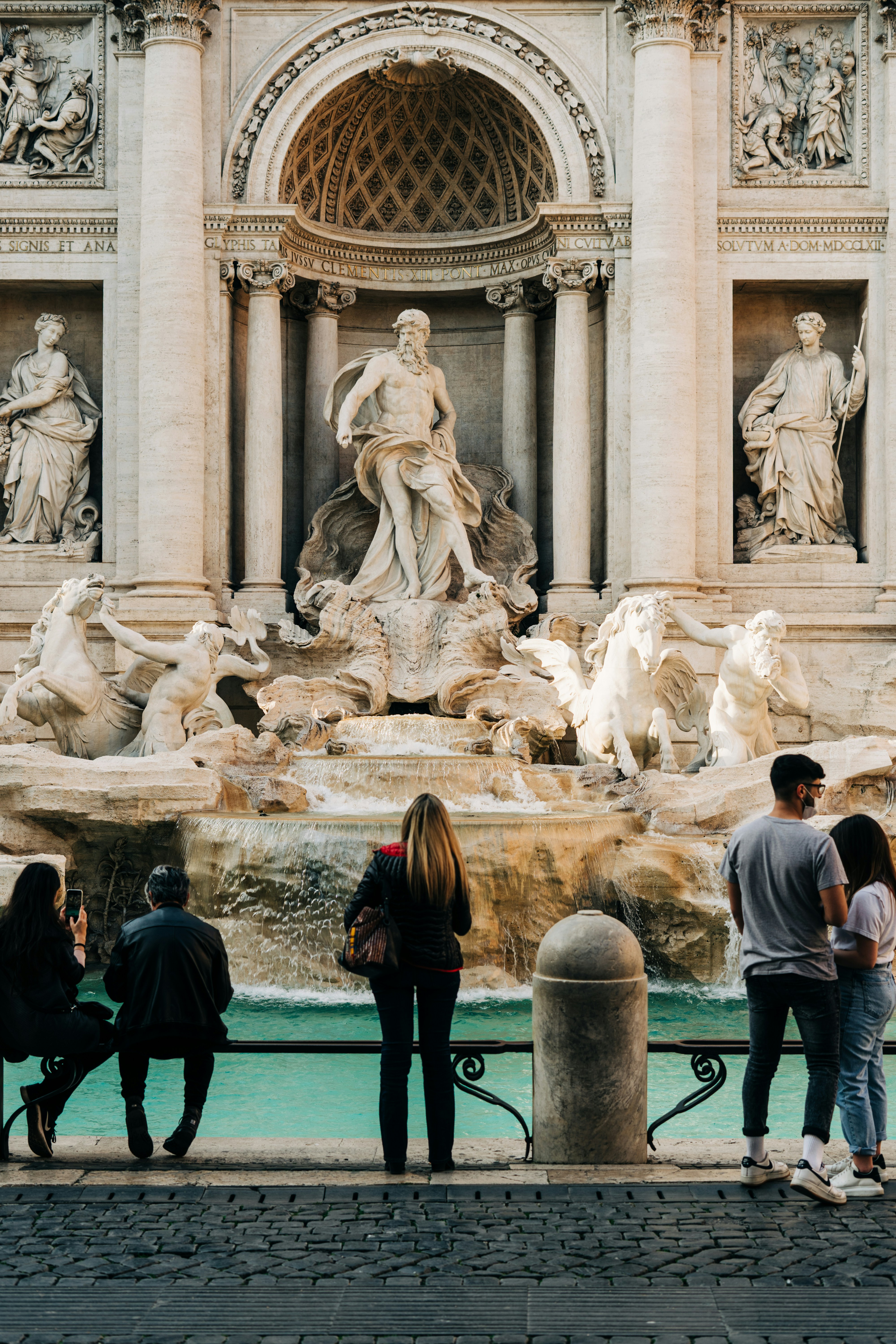 A woman gazes up at one of the statues at the Trevi Fountain in Rome. 